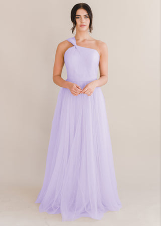 A woman wearing a lilac bridesmaid dress with one shoulder strap on a white background by TH&TH Bridesmaids.