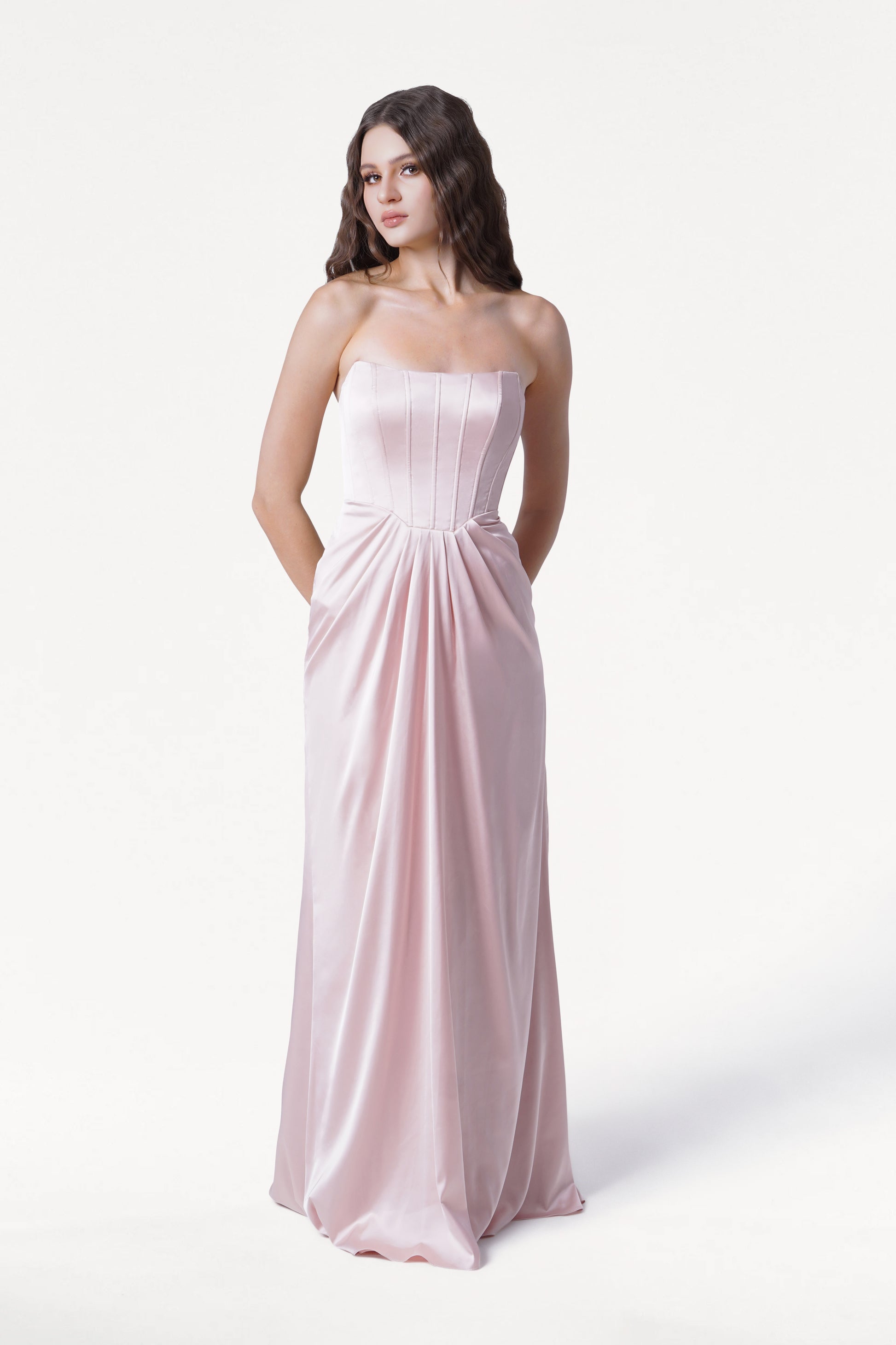 Woman wearing a strapless pink gown on a white background