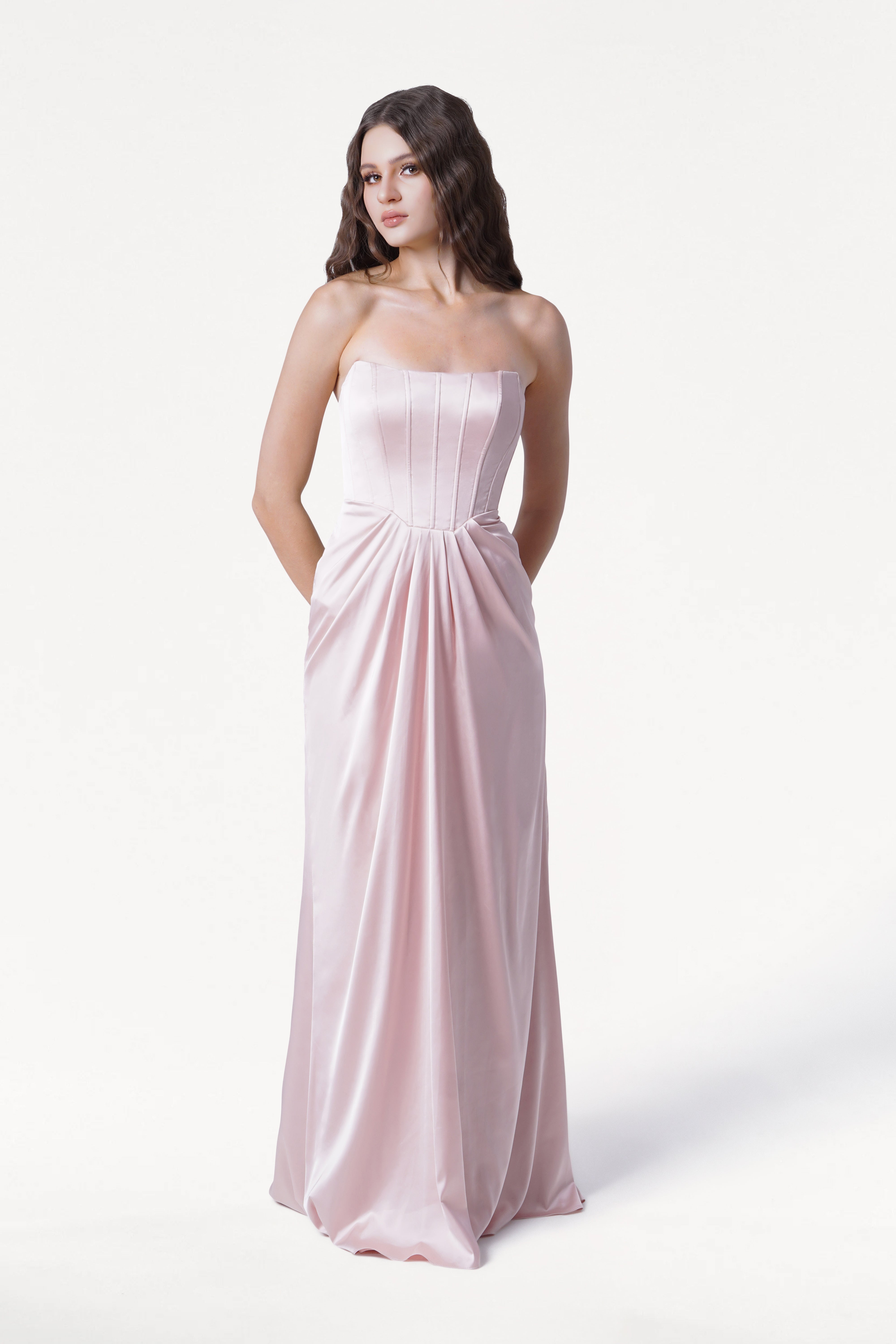 Woman wearing a strapless pink gown on a white background