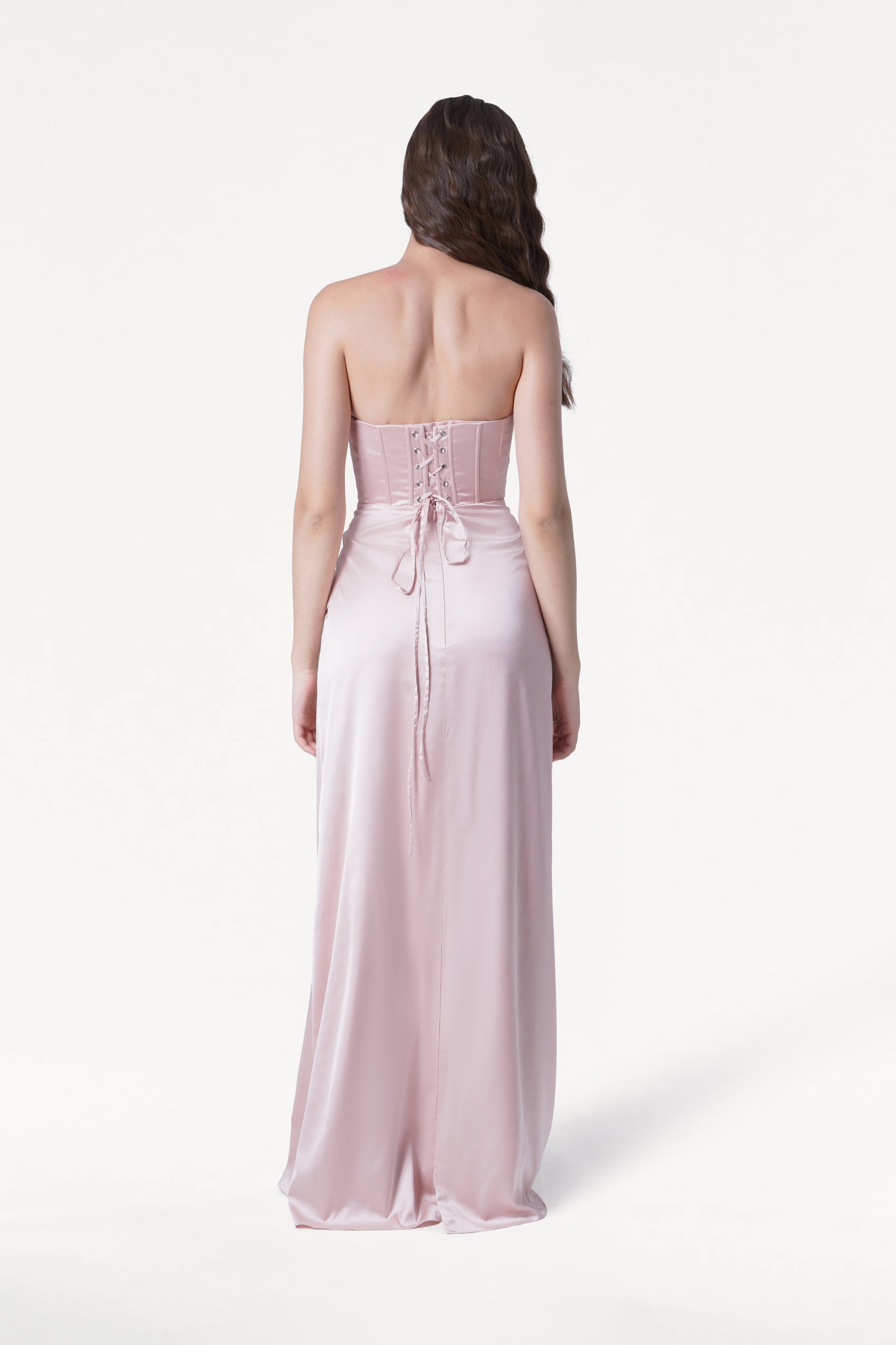 Woman wearing a strapless pink gown on a white background