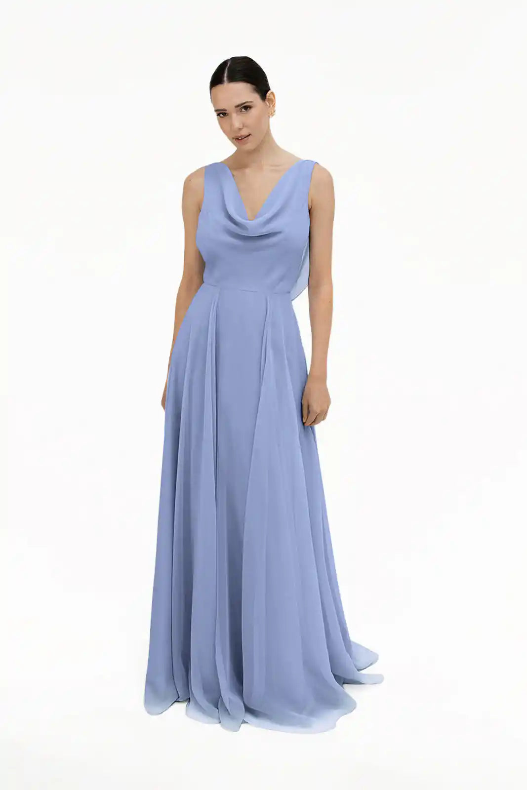 A woman poses gracefully against a white background wearing the TH&TH Athena Bridesmaid Dress in French Blue Chiffon, featuring a draped cowl neckline and flowing skirt. Her dark hair is pulled back.