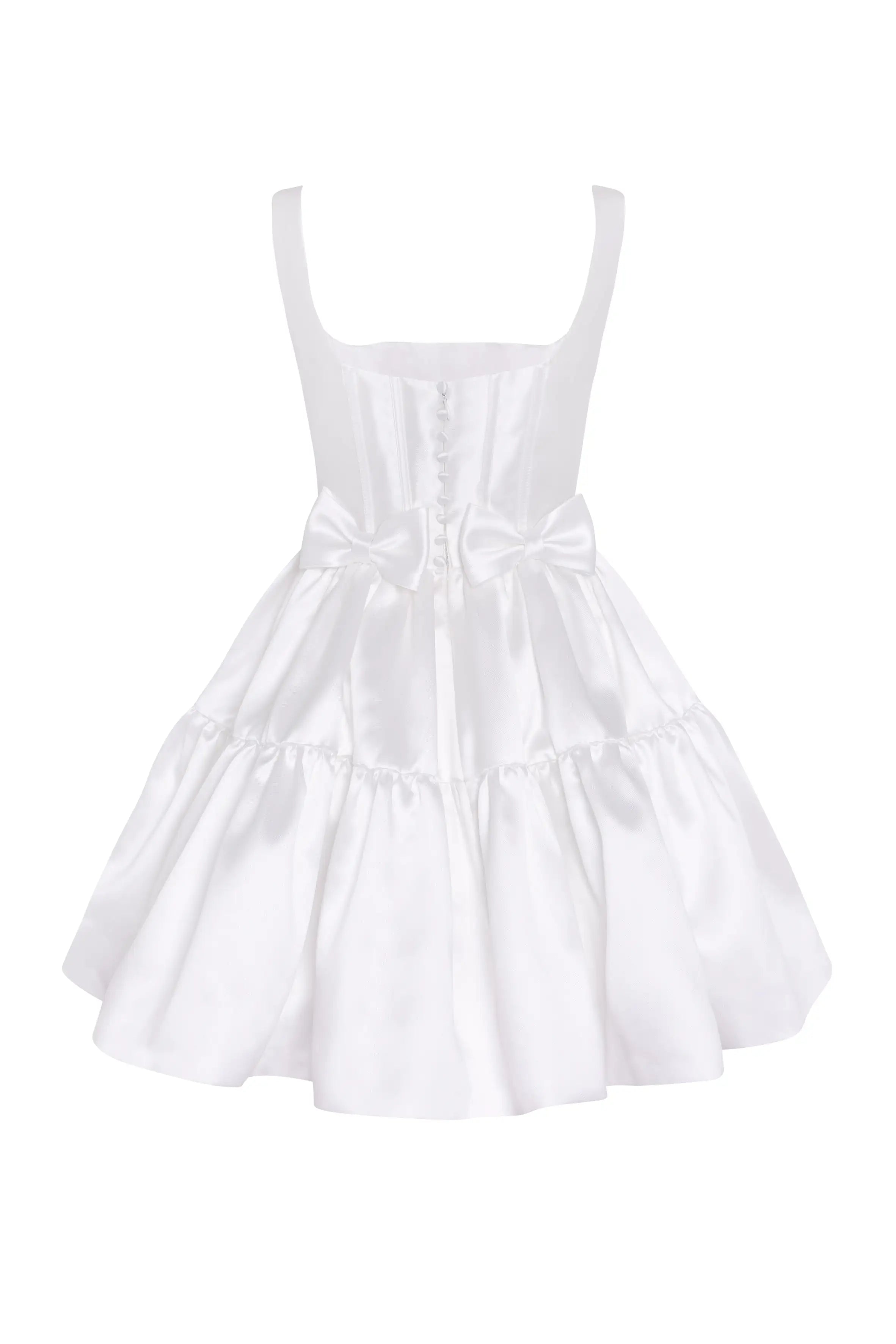 The Bloom Bridal Mini Dress in Ivory by TH&TH is a sleeveless satin twill mini with a corseted bodice, square neckline, button accents, waist bow, and a flared ruffled skirt.