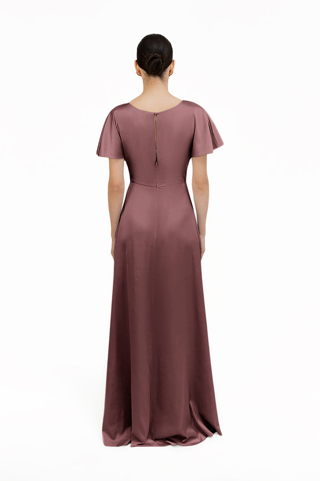 A woman with dark hair in a low bun is shown from the back, wearing the TH&TH Camilla Bridesmaid Dress—a floor-length, short-sleeved gown in chocolate brown satin with a zipper down the upper back—against a plain white background.