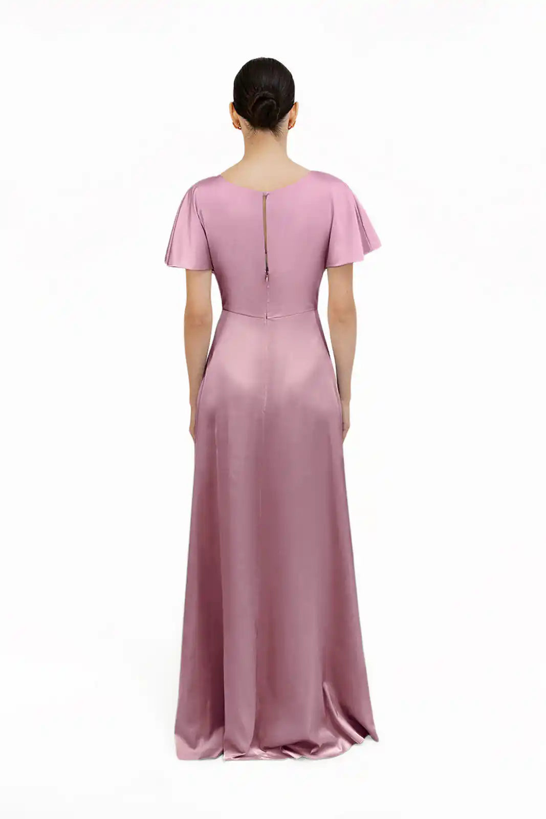 A person faces away, modeling the TH&TH Camilla Bridesmaid Dress in rose pink satin—floor-length, size-inclusive, with short sleeves, a fitted waist, and a back zipper—against a plain white background.