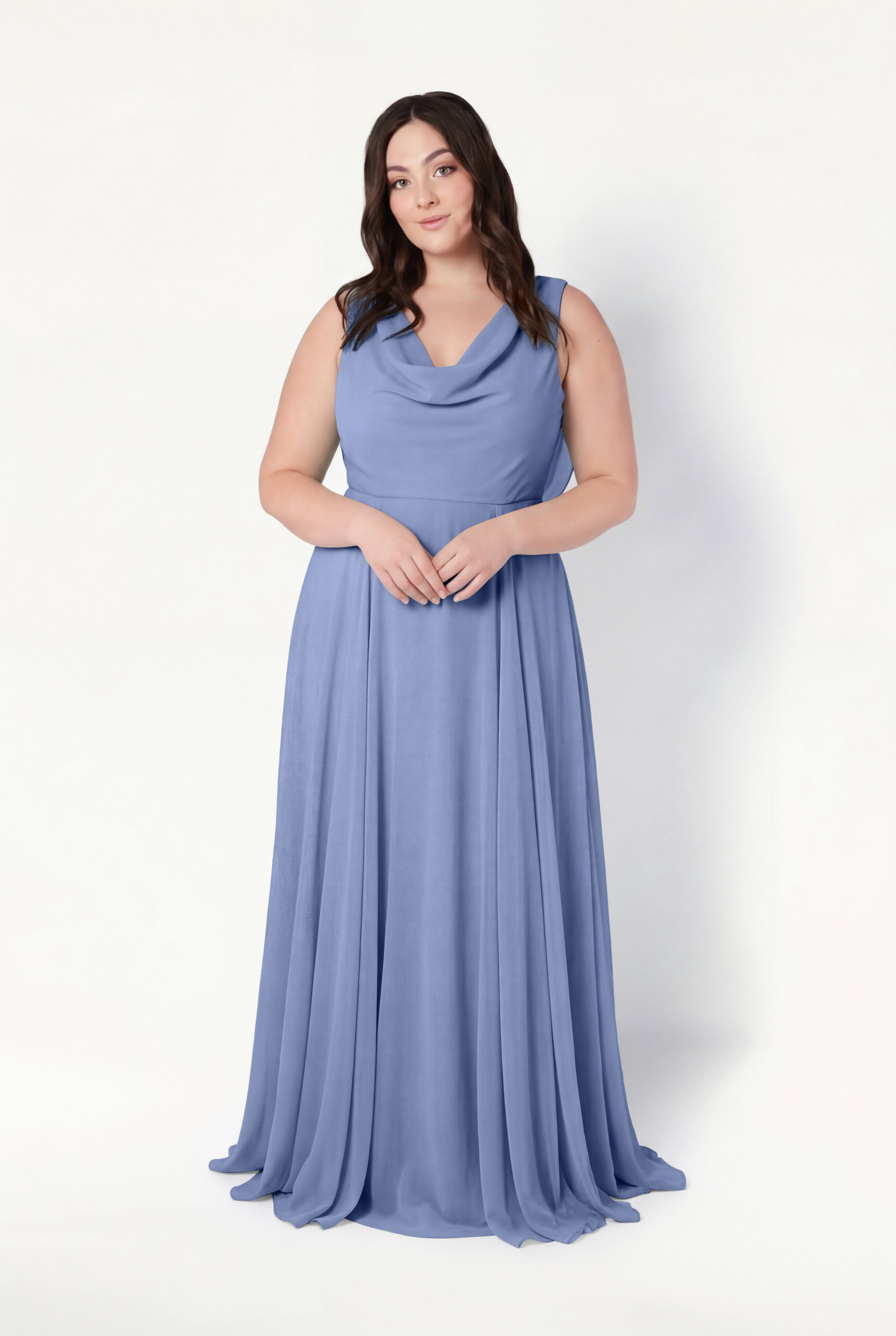 A woman with long brown hair wears the TH&TH Athena Bridesmaid Dress in French Blue Chiffon, featuring a sleeveless, floor-length design and cowl neck, standing against a plain white background with her hands clasped in front.