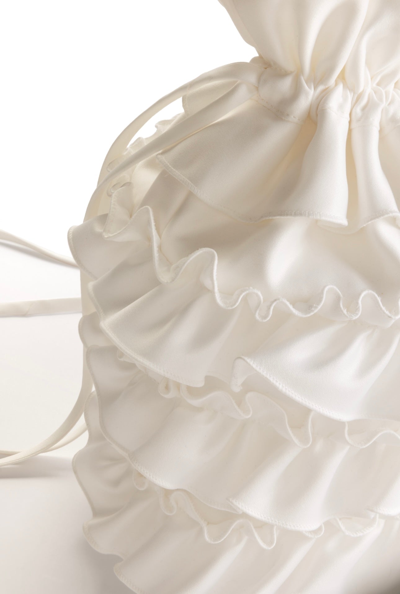 A close-up of the TH&TH 'Happily Ever After' Ruffle Bridal Bag in ivory, showing its layered ruffles and drawstring closure, set against a plain white background.