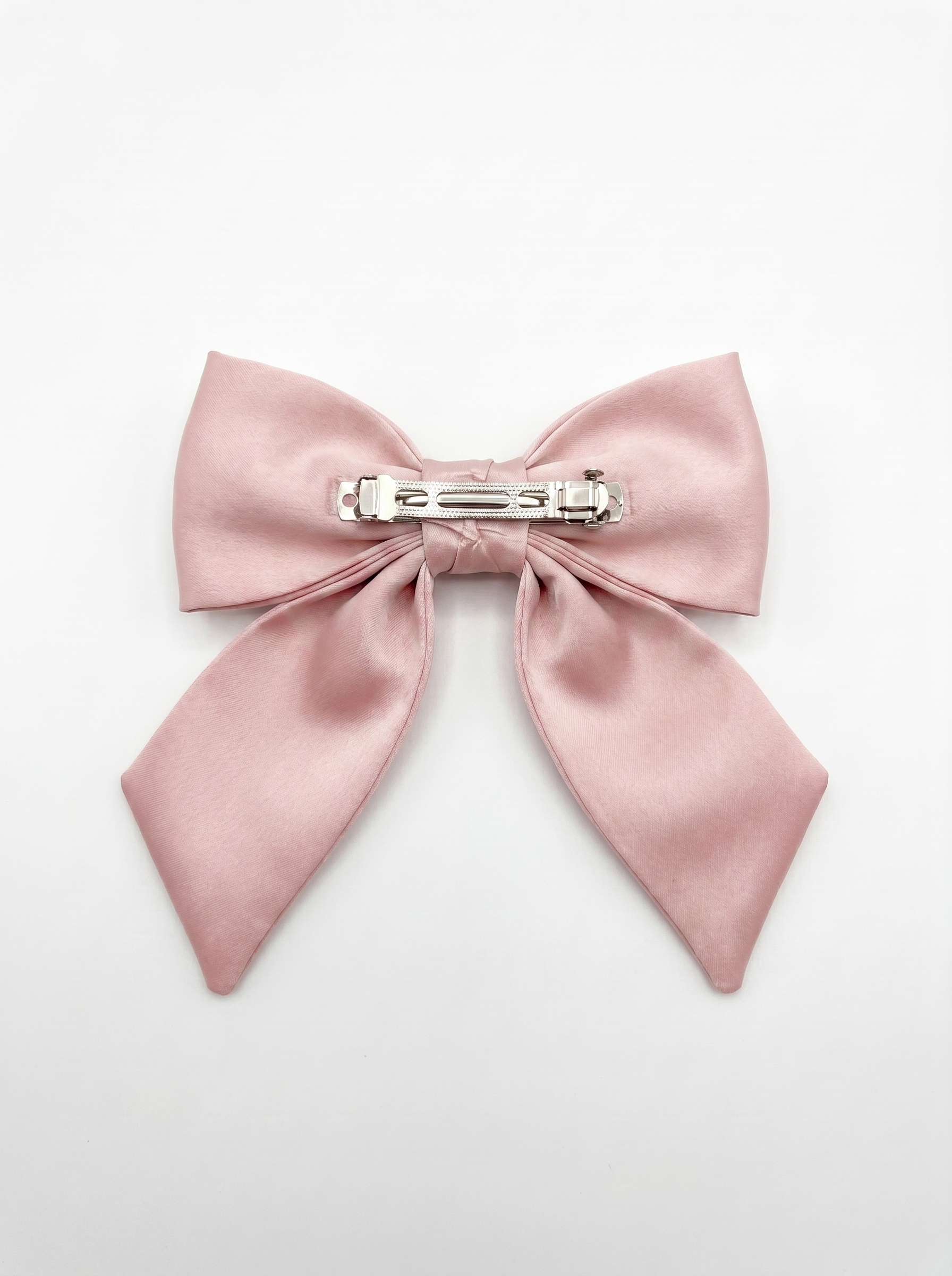 Pink satin bow hair clip on a light gray background