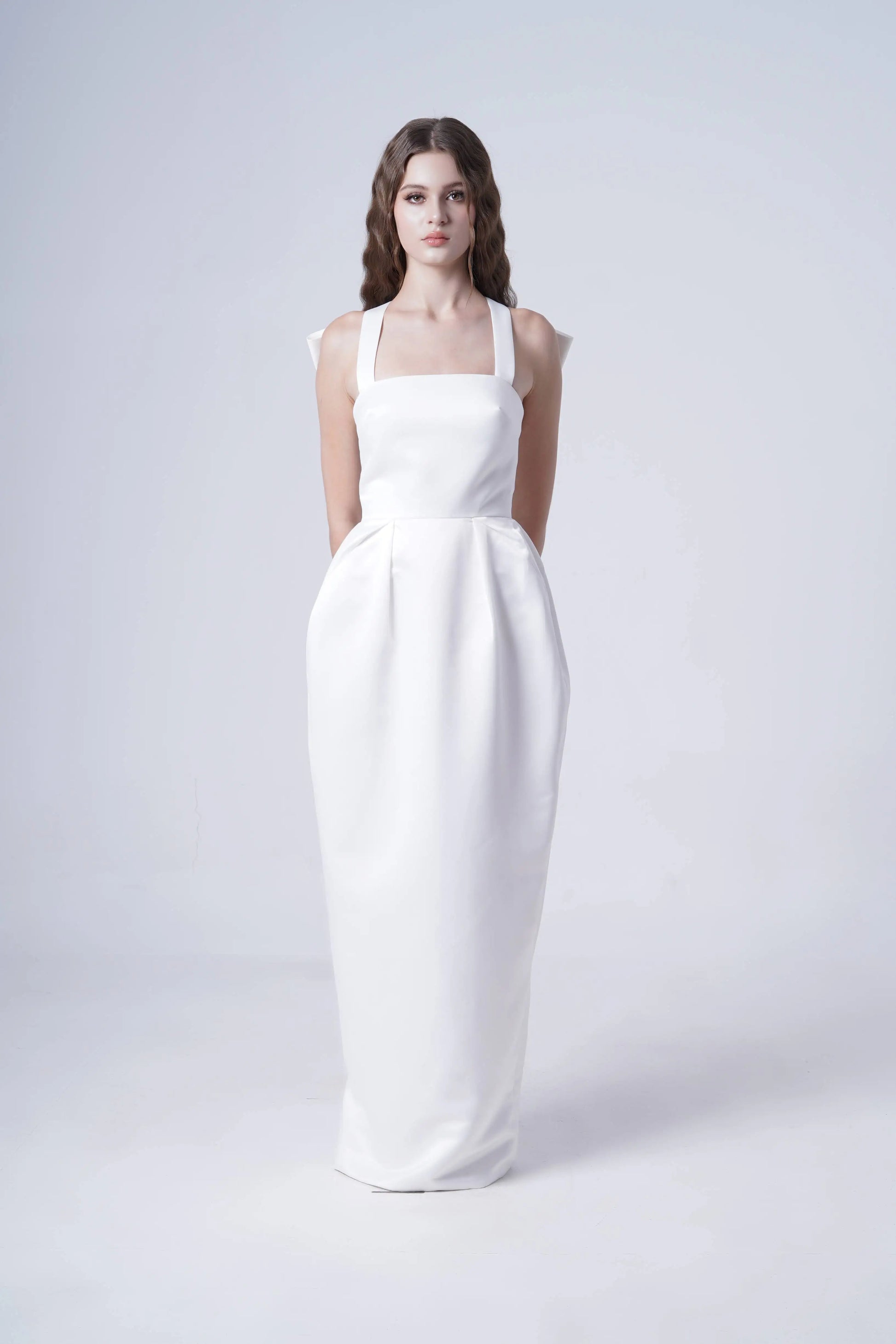 Woman wearing a white dress on a light gray background