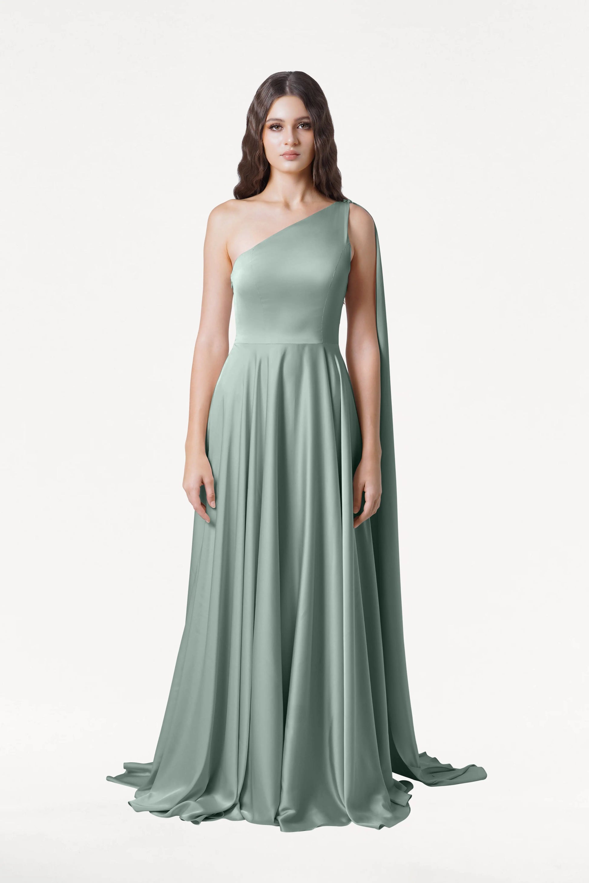 A woman faces forward, wearing the TH&TH Lyra Bridesmaid Dress in Dusty Eucalyptus Satin—a size-inclusive, one-shoulder gown with a flowing skirt and draped side accent—set against a plain white background.