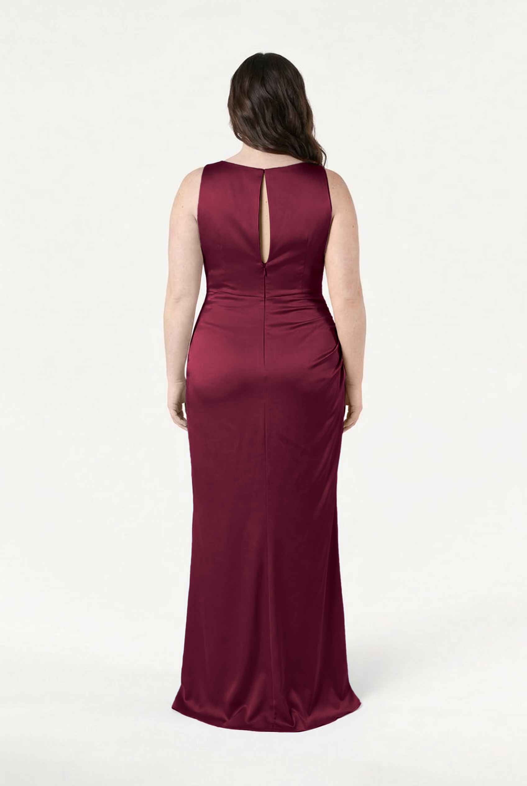 A woman faces away in the TH&TH Nala Bridesmaid Dress in Merlot Satin, highlighting the size-inclusive design and keyhole back detail. The smooth, fitted satin fabric flatters her silhouette against a plain white background.