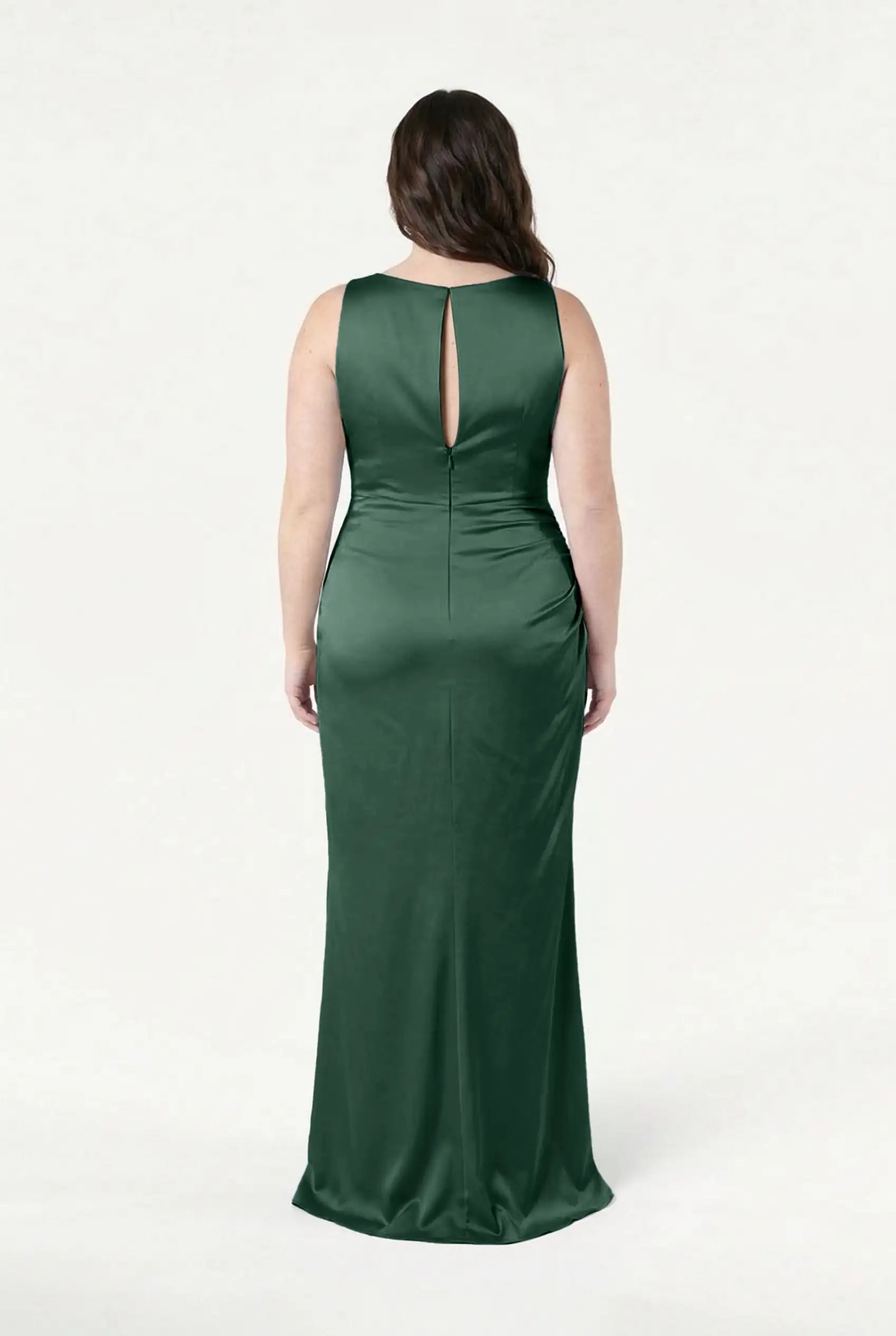 A woman with long, wavy brown hair is seen from behind wearing the TH&TH Nala Bridesmaid Dress in Olive Grove Satin—a sleeveless, floor-length gown with a small keyhole back—set against a plain white background.