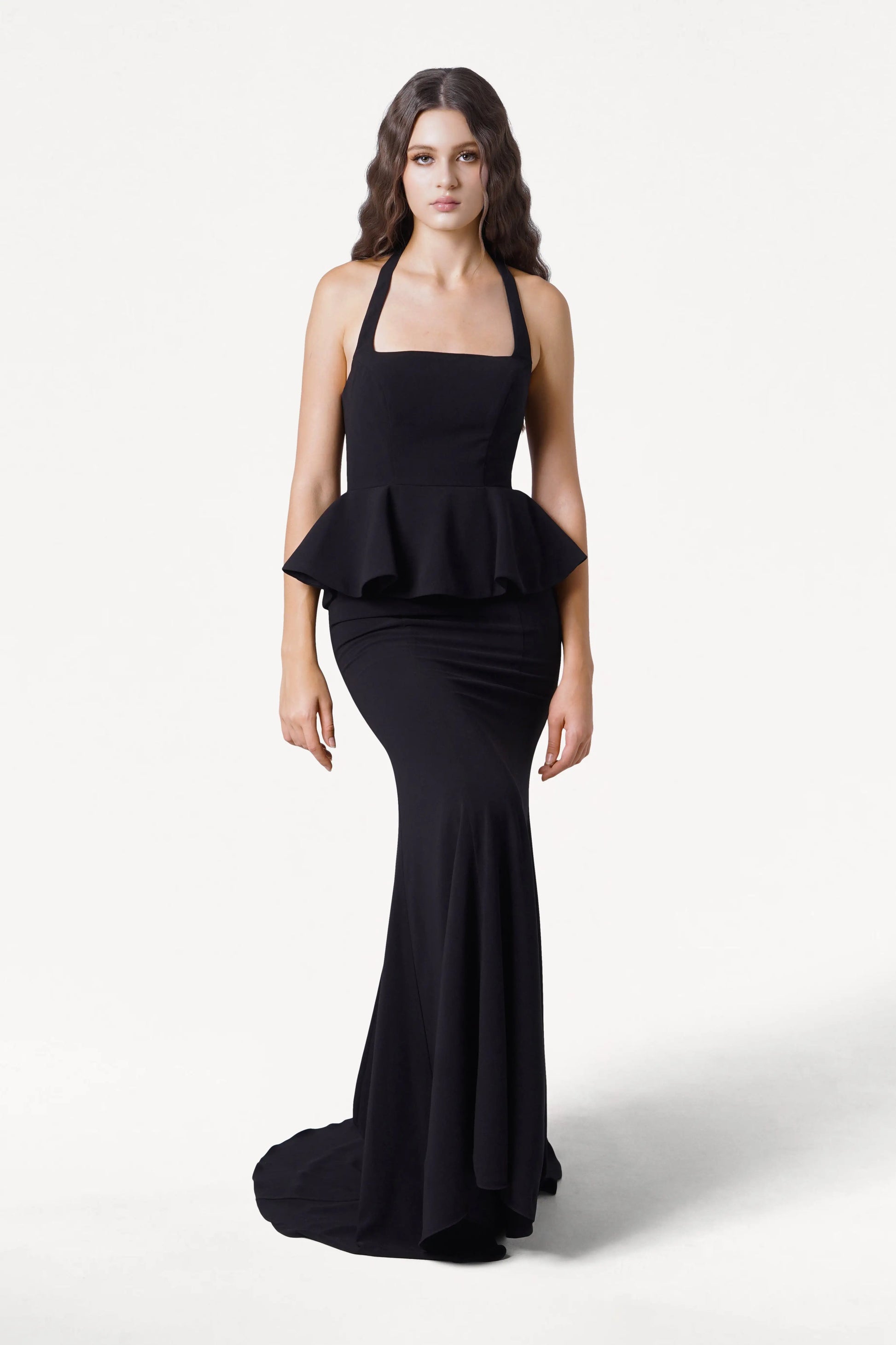 Woman wearing a black peplum gown on a white background