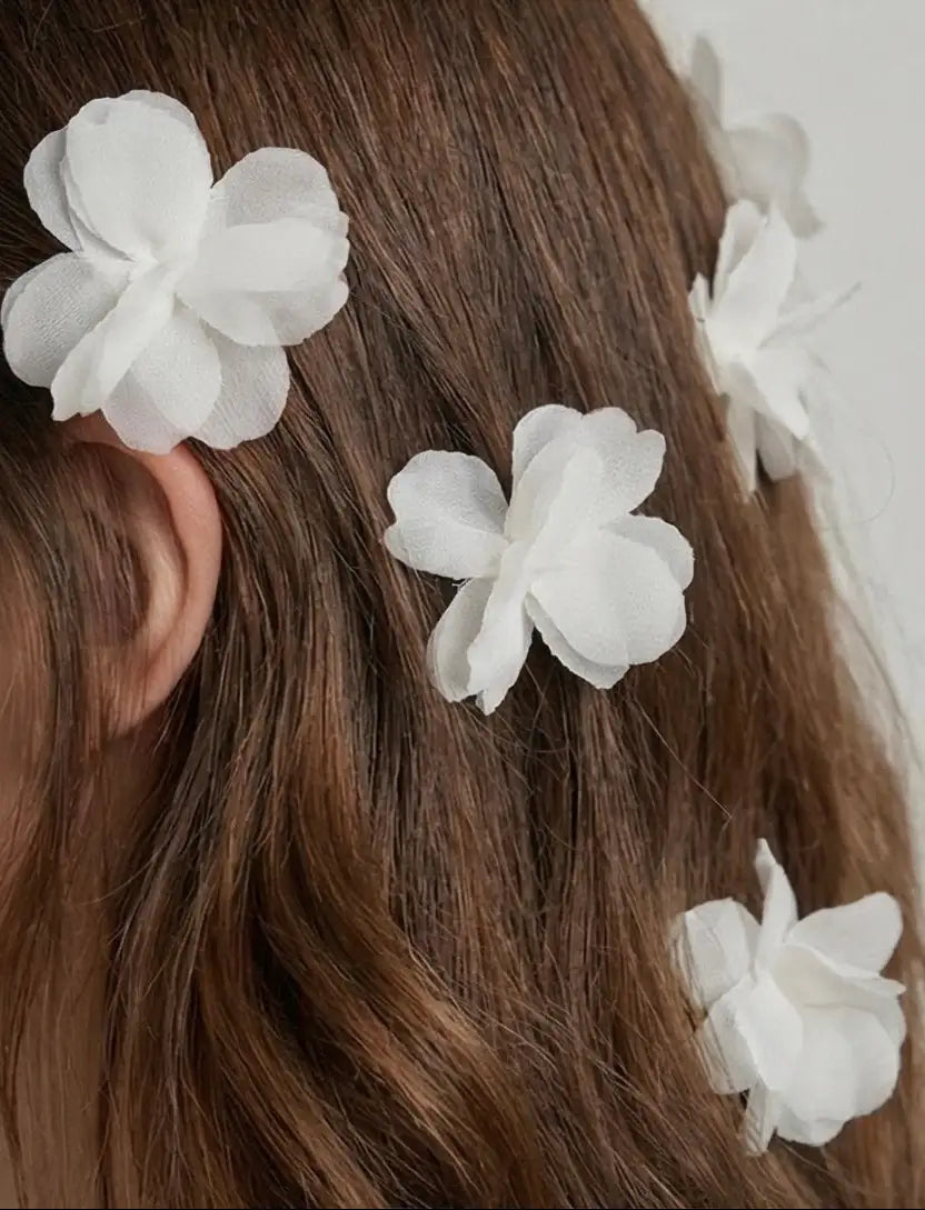 TH&TH Petal Hair Pins 3pcs are clipped into wavy brown hair, creating a delicate and decorative bridal hairstyle. The close-up image highlights these elegant wedding hair accessories from the side and back.