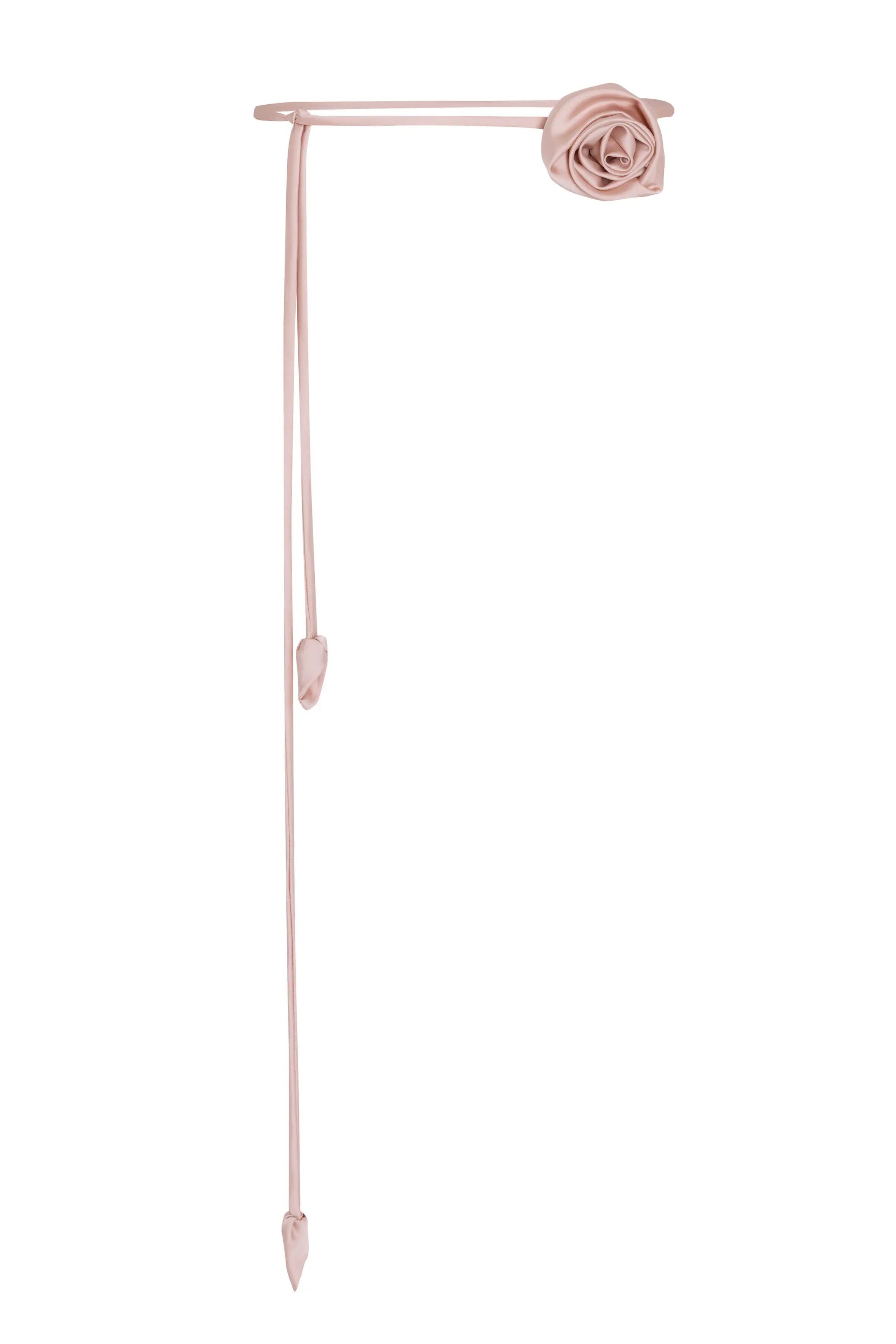 The TH&TH Rose Corsage is a pale pink satin choker with a rose-shaped decoration and two pointed ribbon tails. Its delicate, minimalist design makes it a charming wedding accessory.