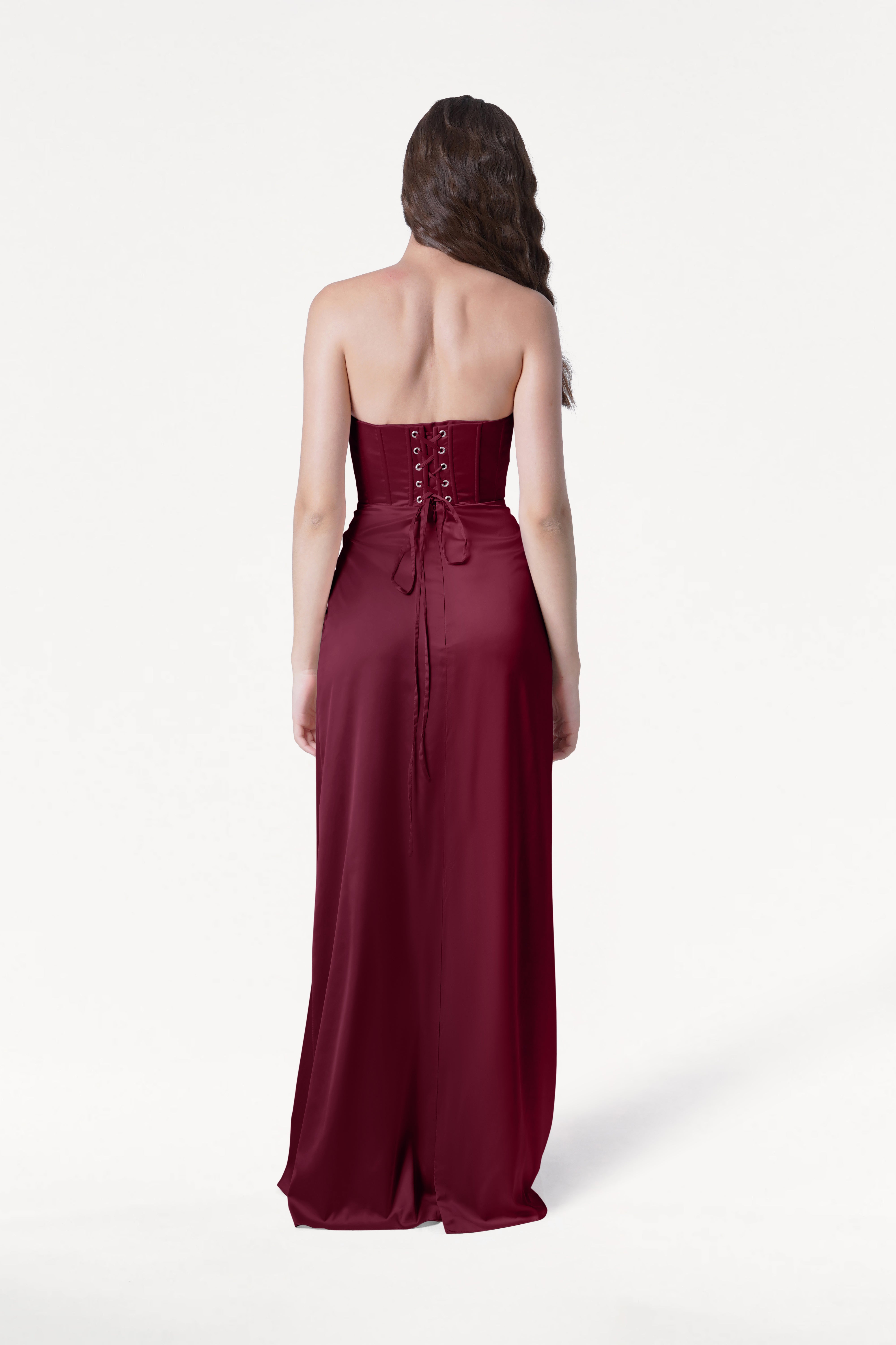 Woman wearing a burgundy strapless gown on a white background
