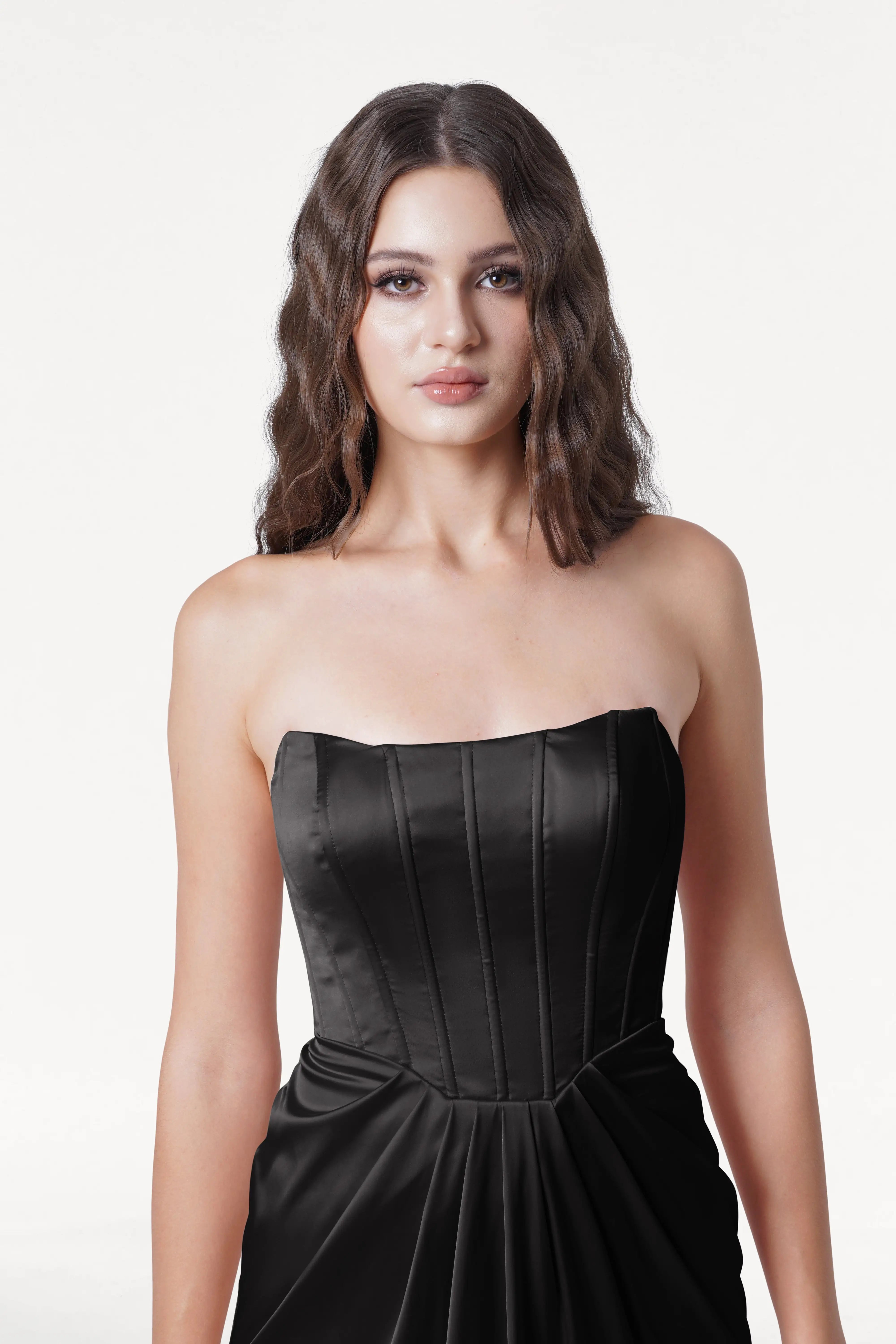 Woman wearing a black strapless dress on a white background