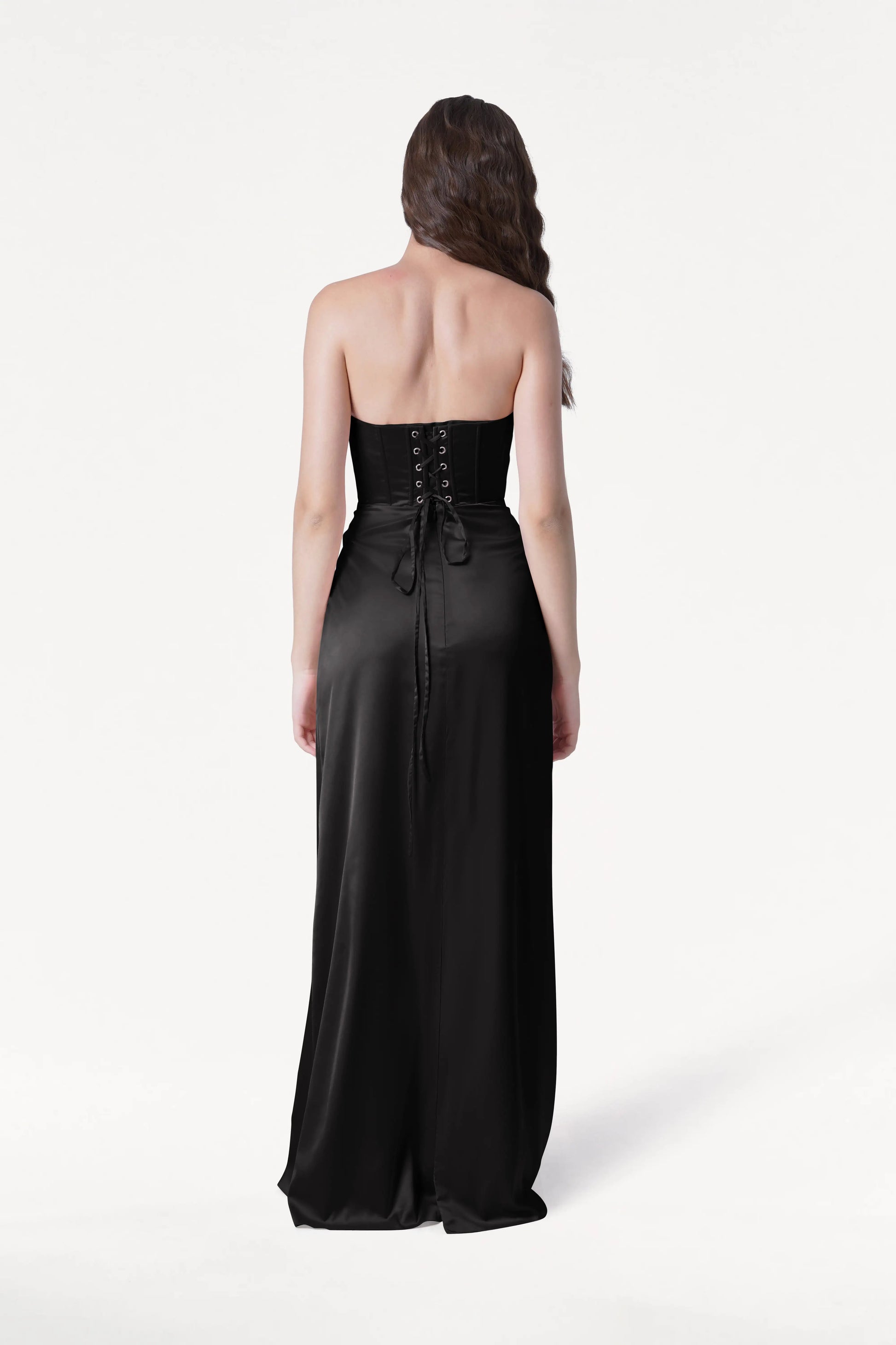 Woman wearing a black strapless gown on a white background