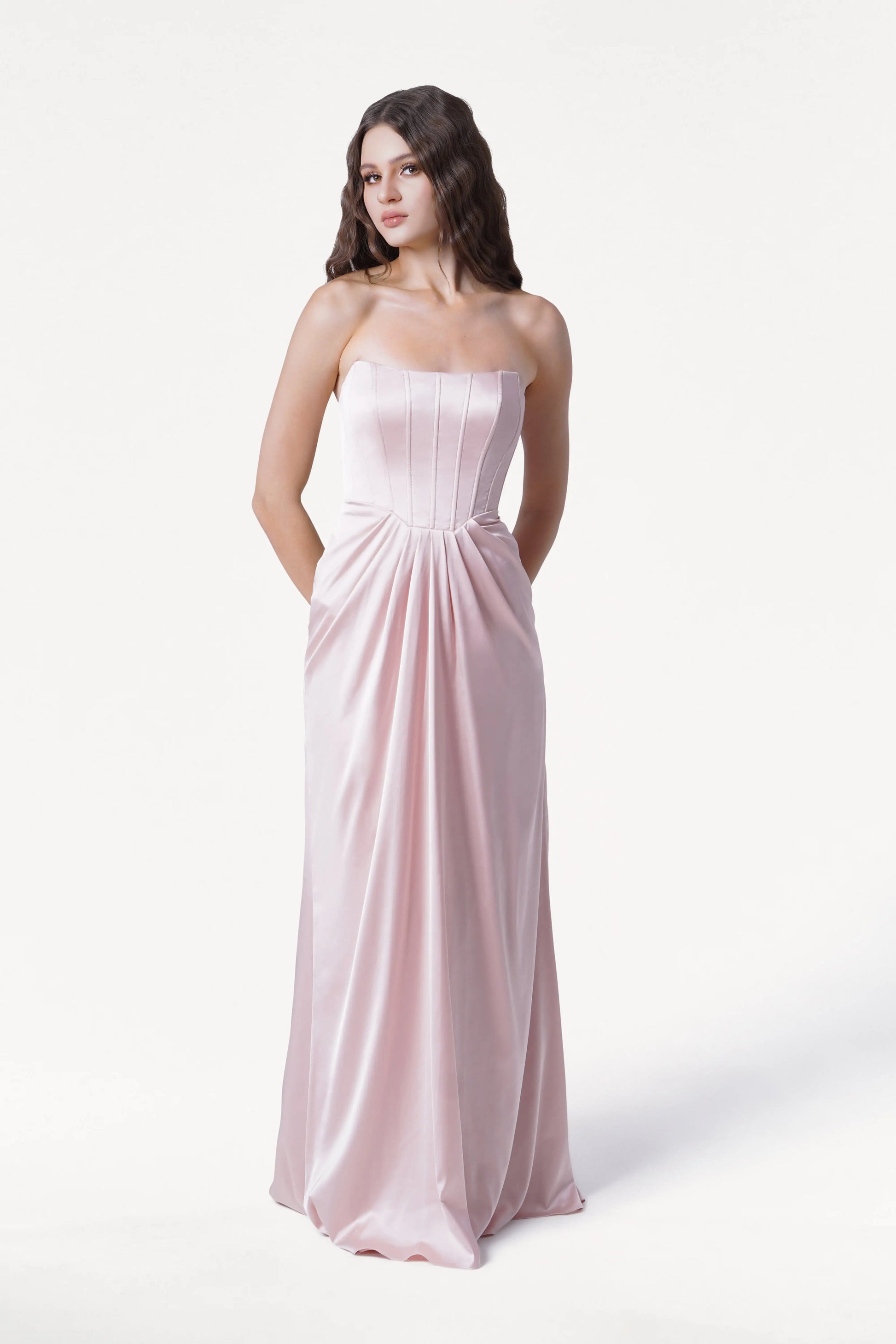 Woman wearing a strapless pink gown on a white background