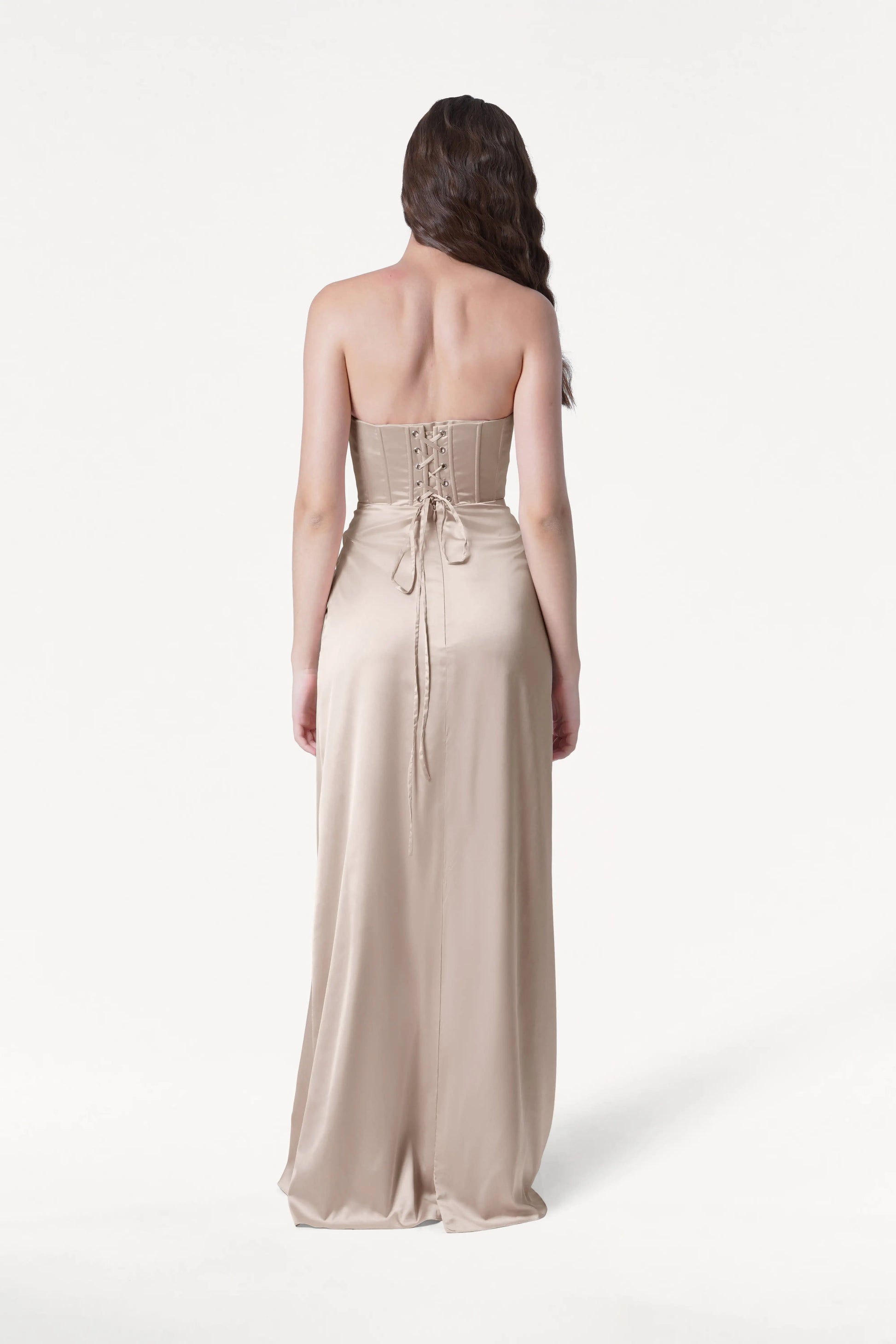 Woman wearing a strapless Champagne gown on a white background