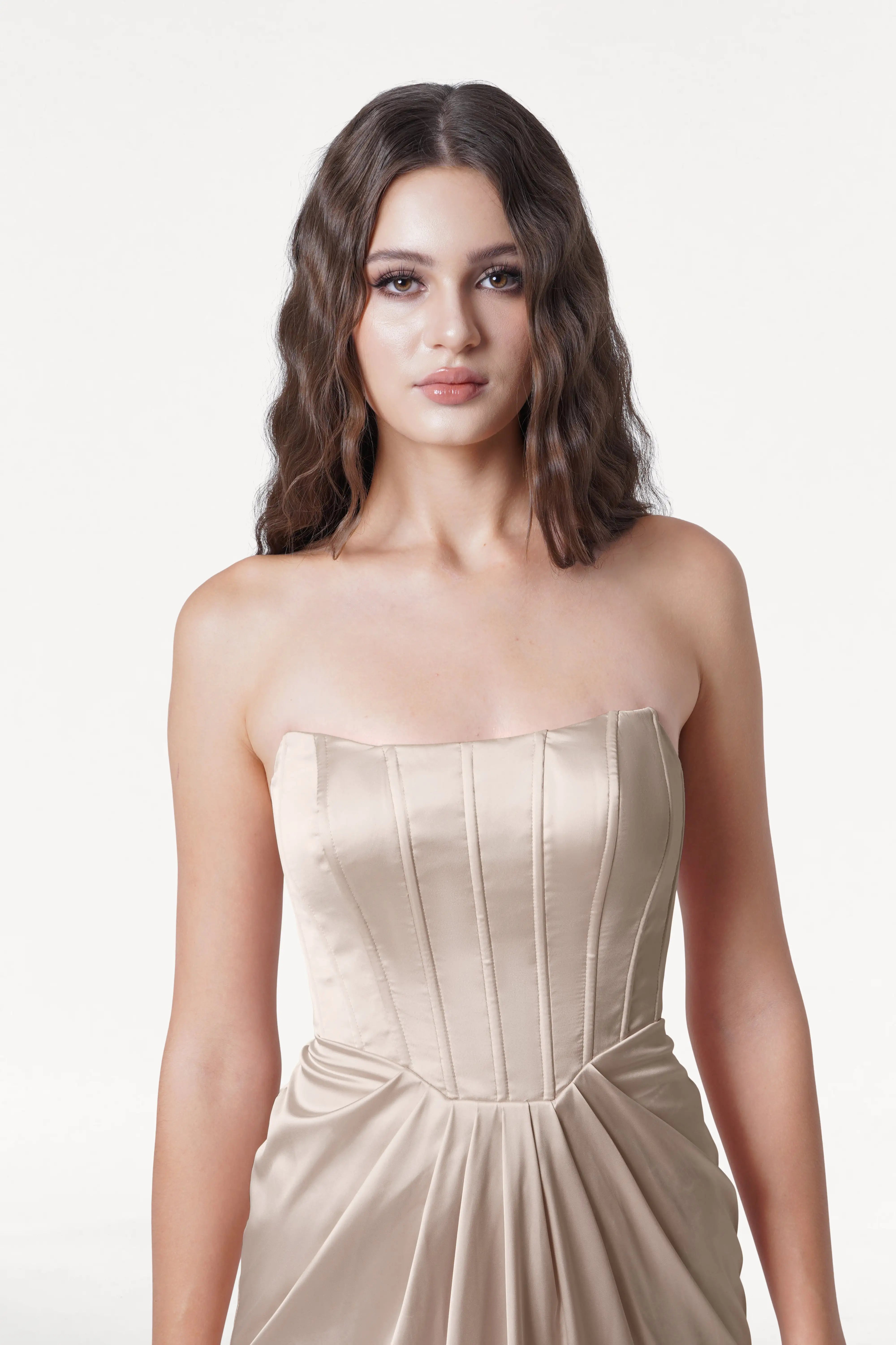 Woman wearing a strapless Champagne dress on a white background