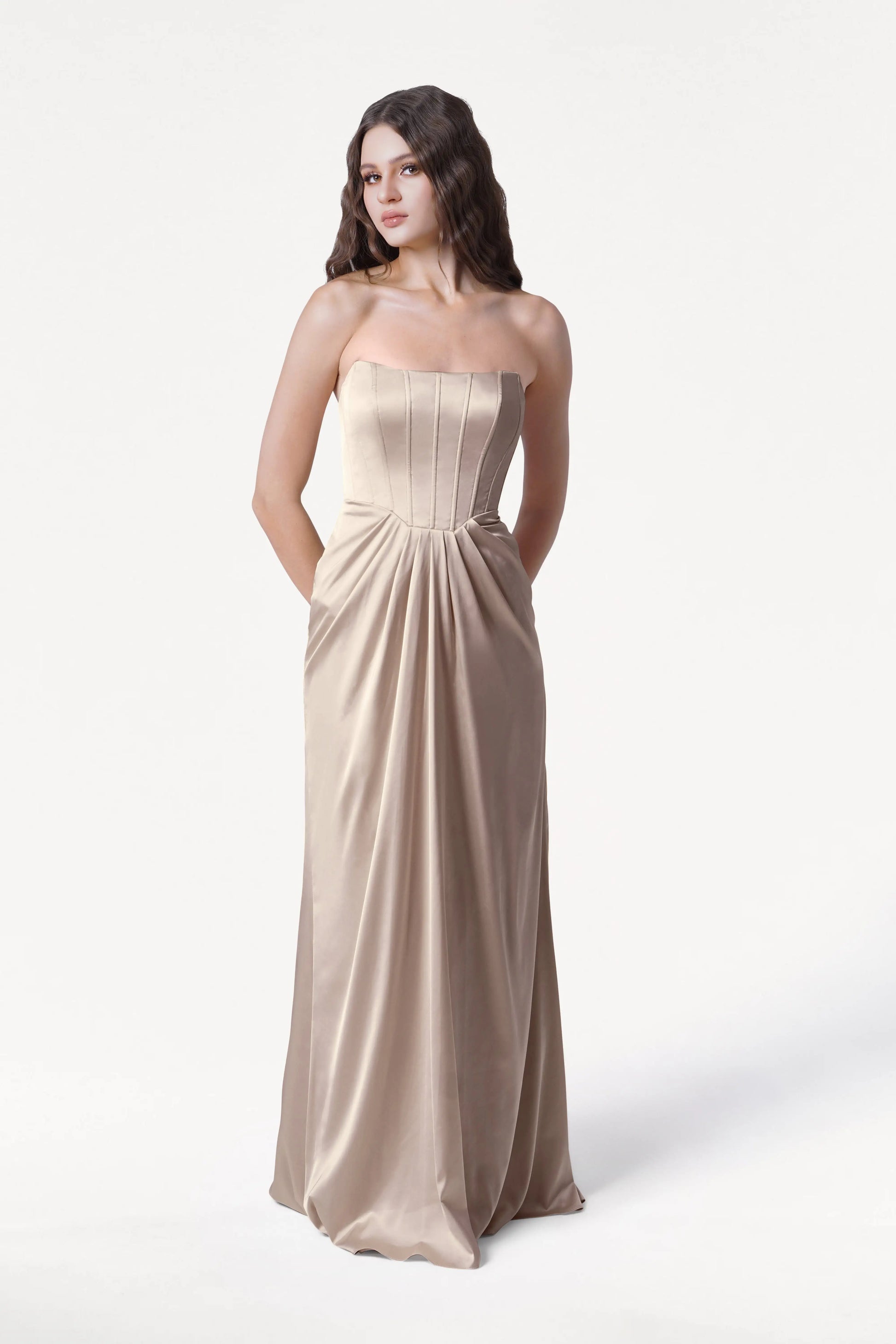 Woman wearing a strapless Champagne gown on a white background
