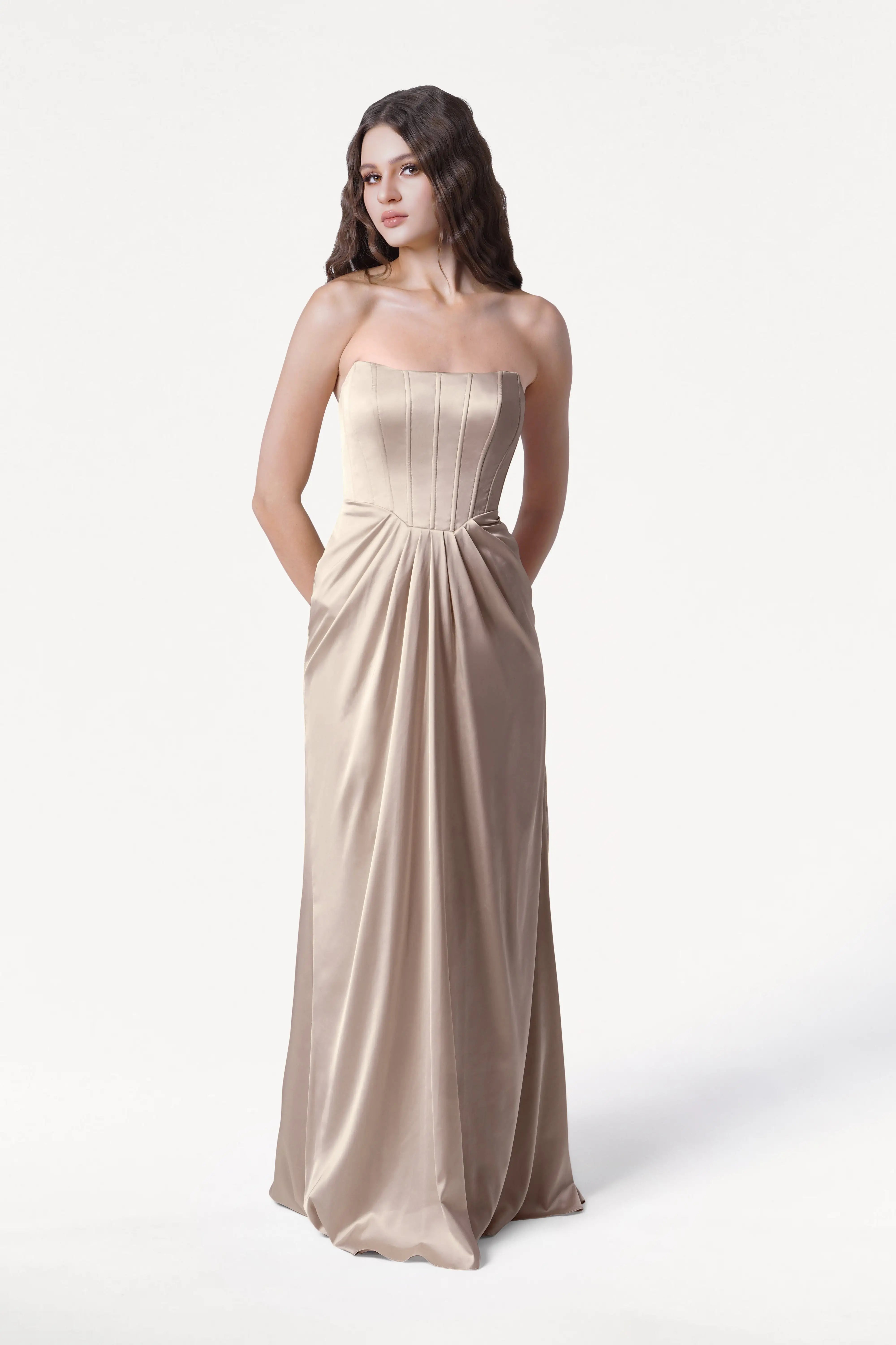 Woman wearing a strapless Champagne gown on a white background