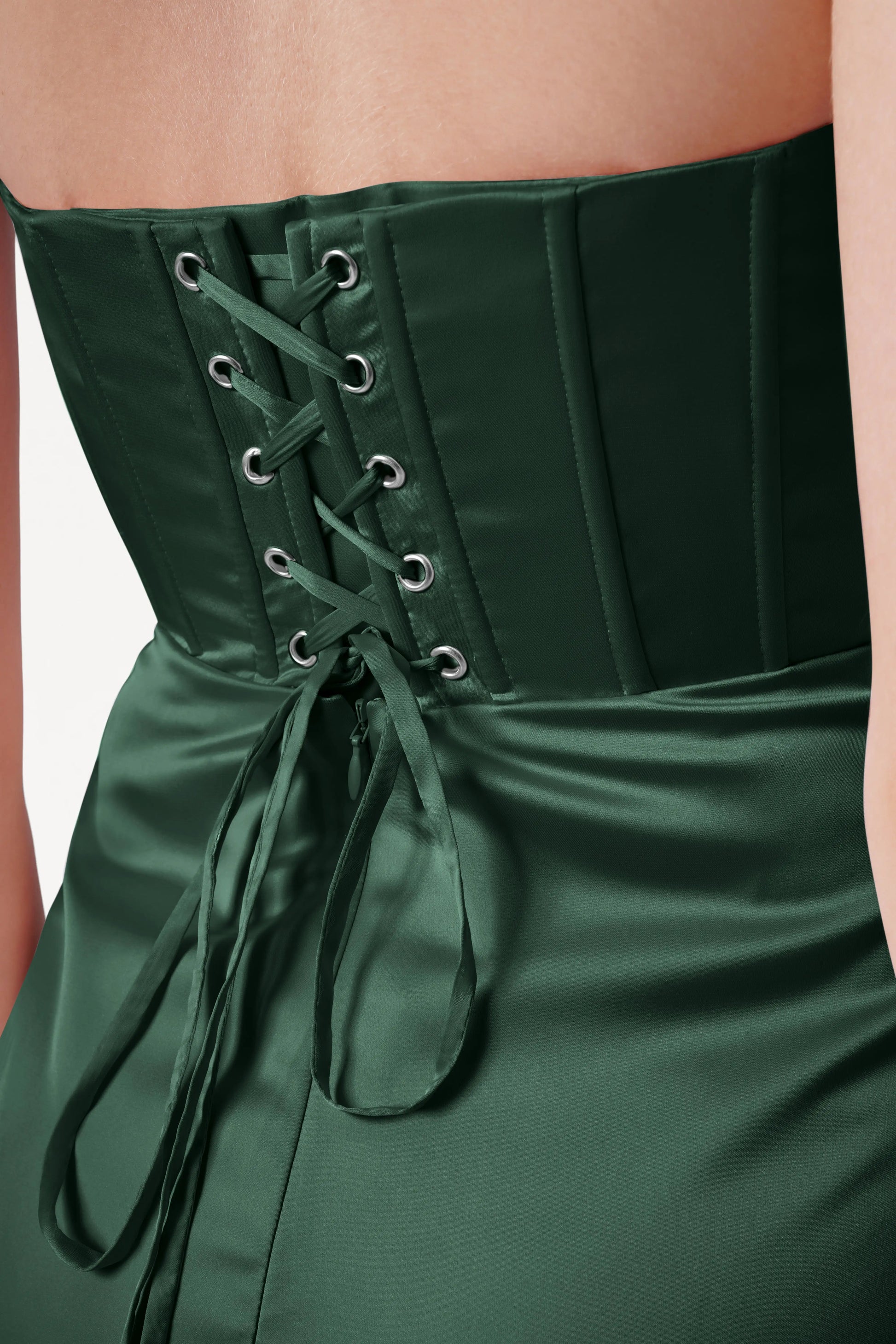 Green corset dress with lace-up back on a neutral background