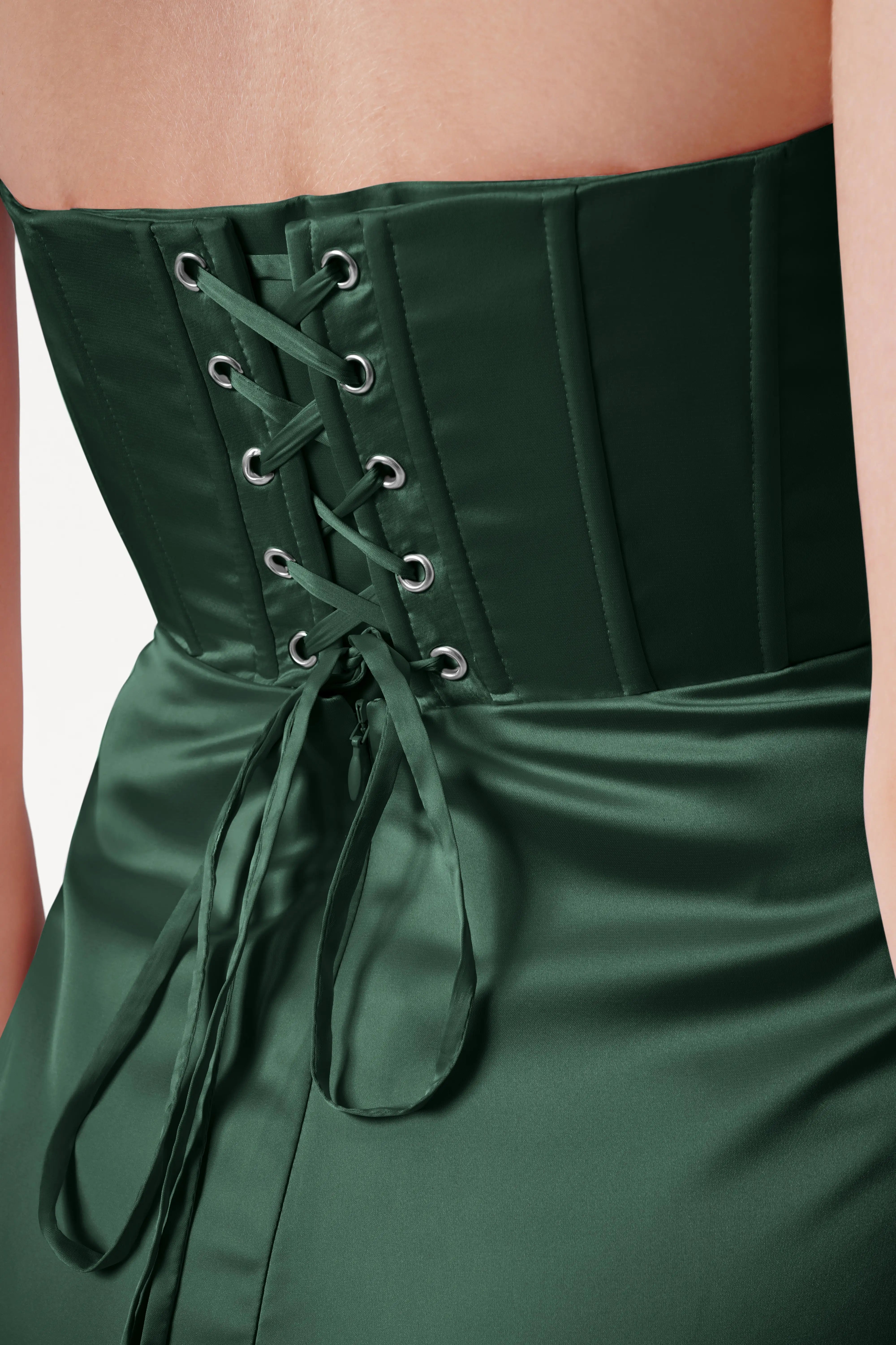 Green corset dress with lace-up back on a neutral background