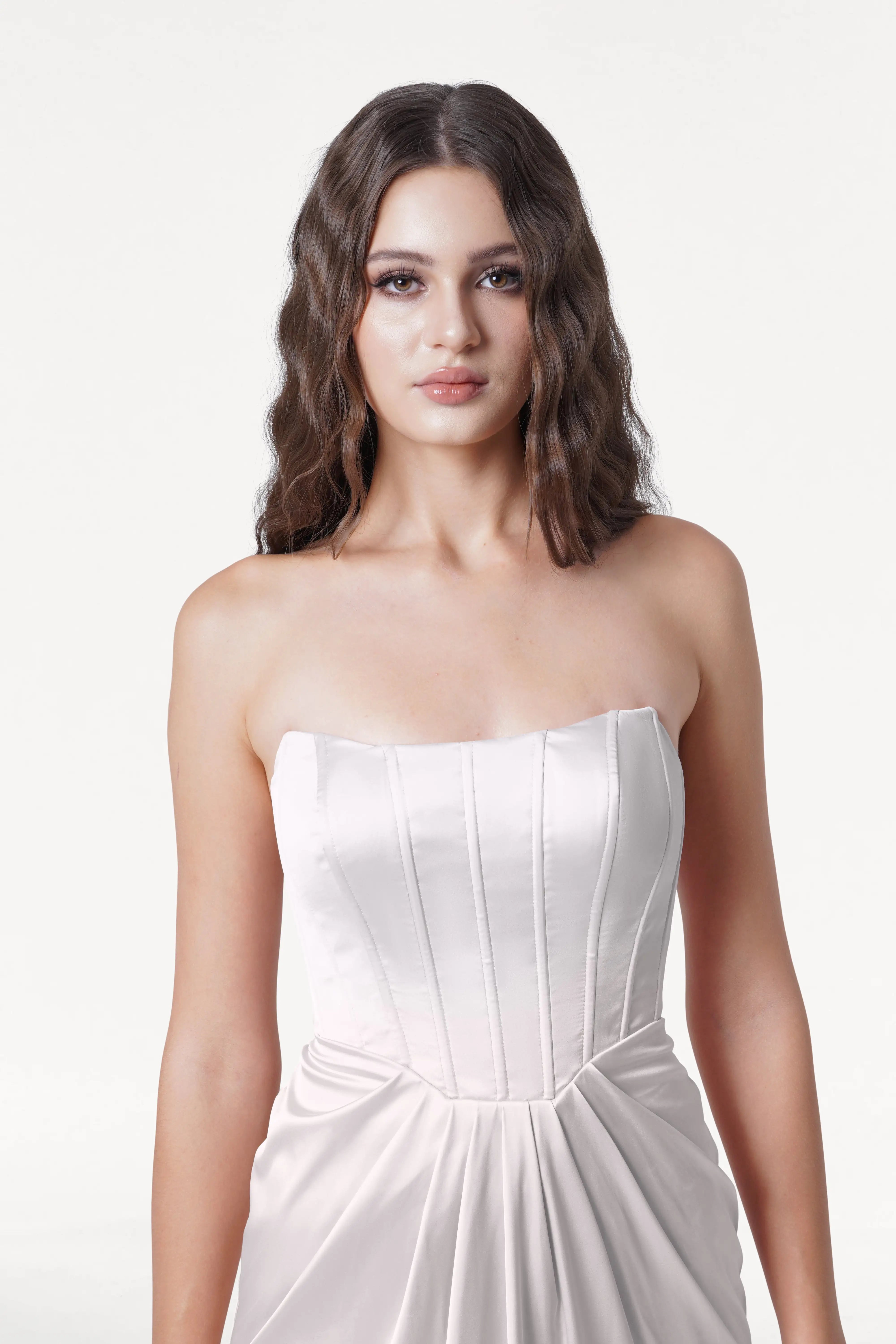 Woman wearing a strapless white dress on a white background