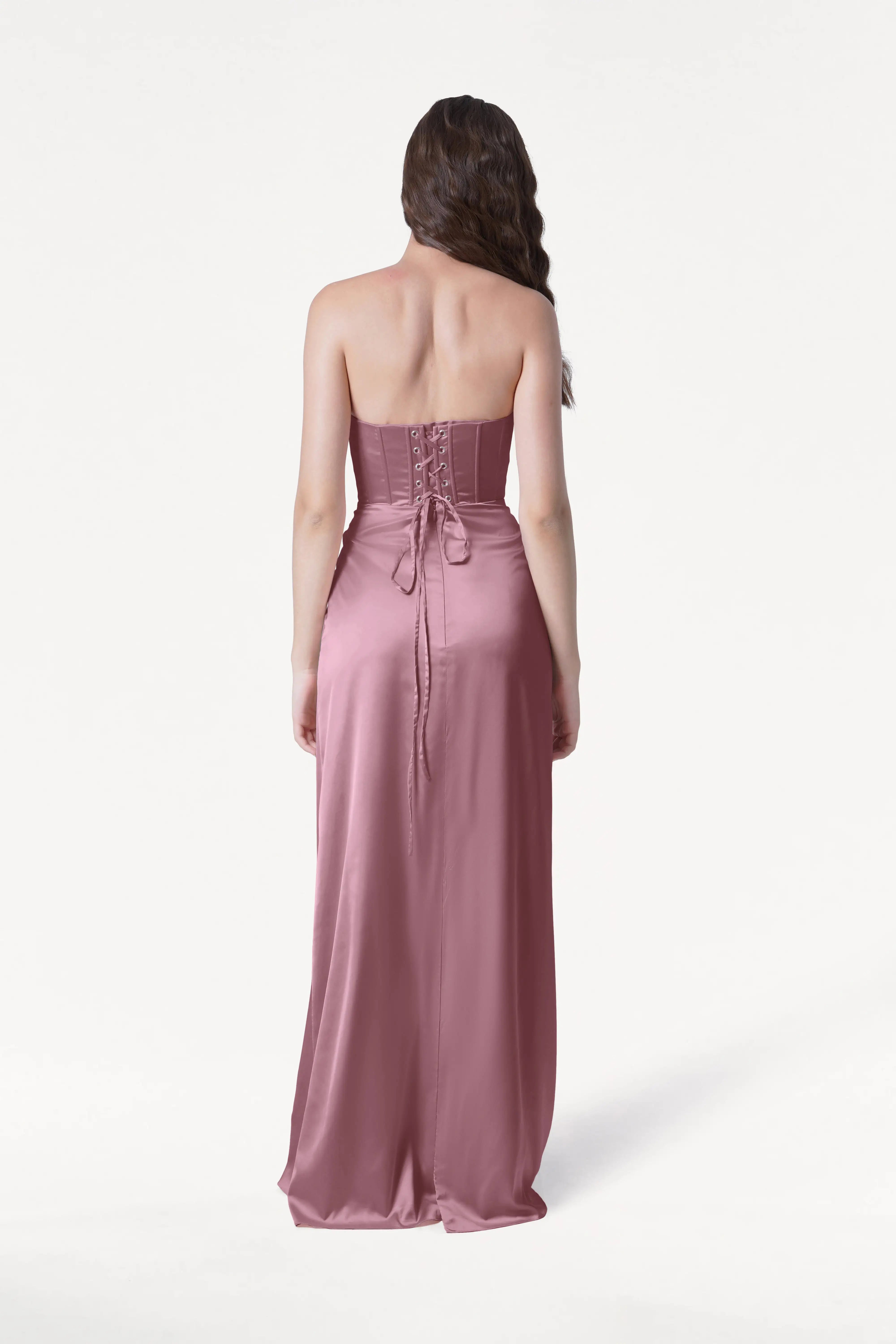 Woman wearing a strapless pink gown on a white background