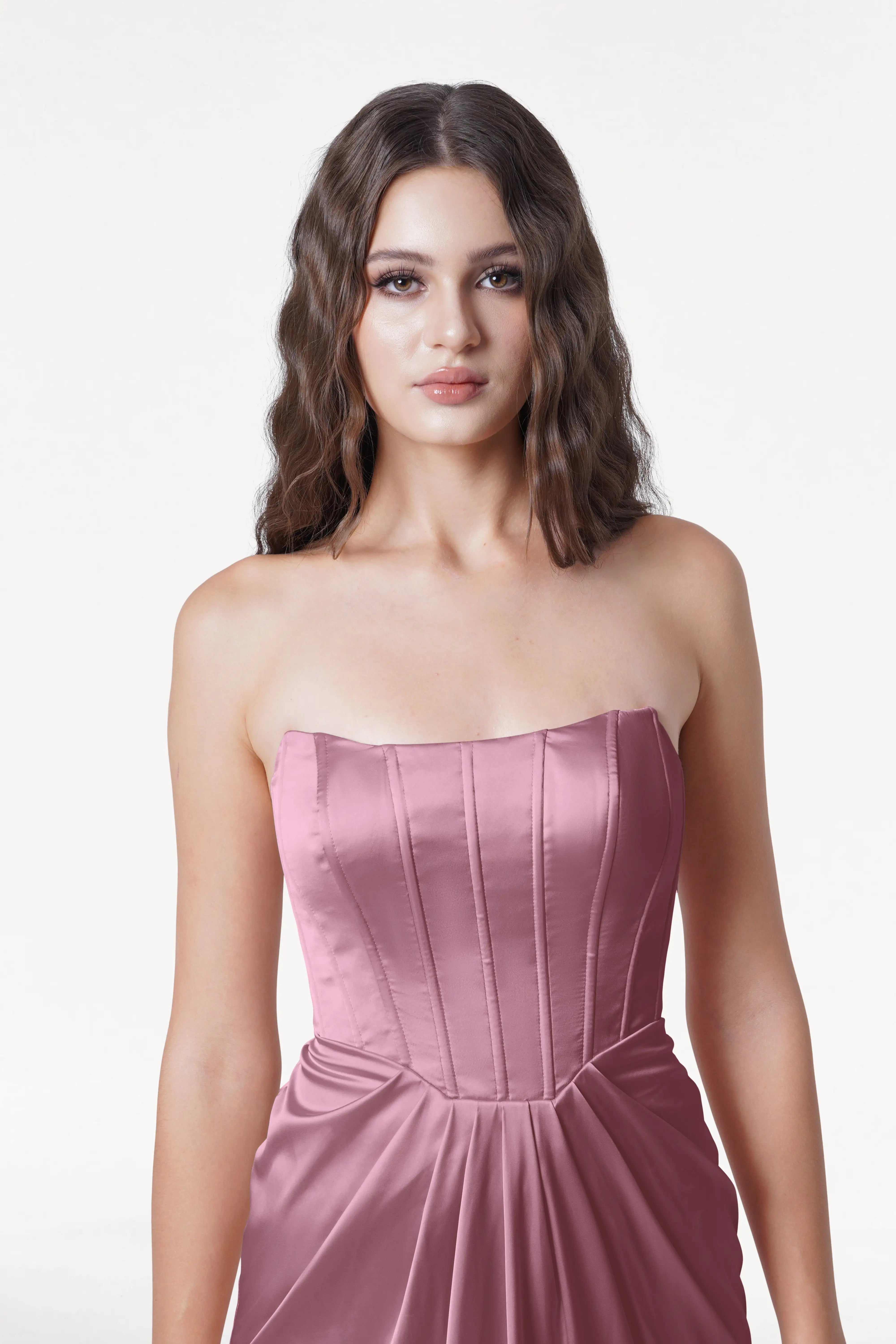 Woman wearing a strapless pink dress on a white background