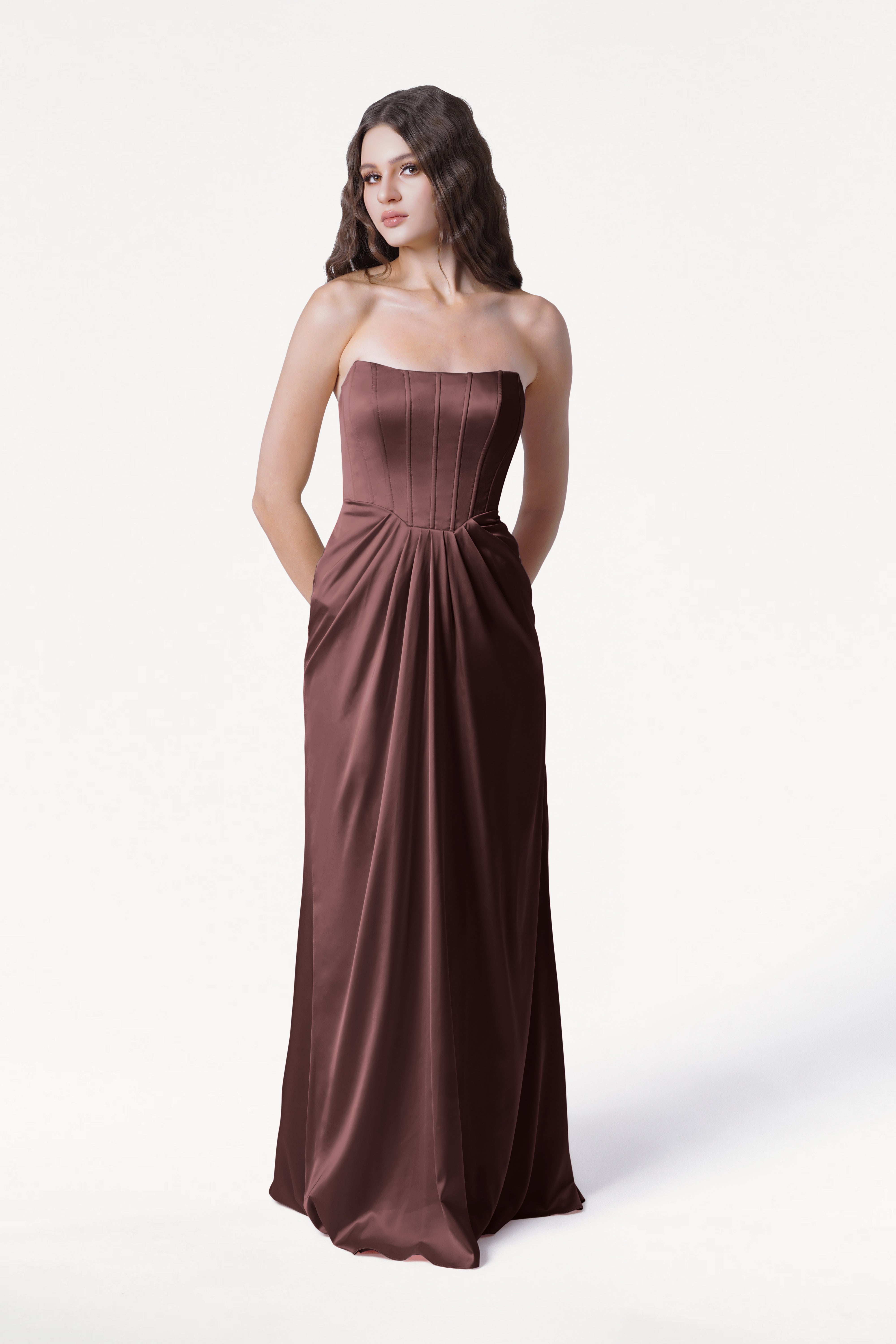 Woman wearing a strapless brown evening gown on a white background