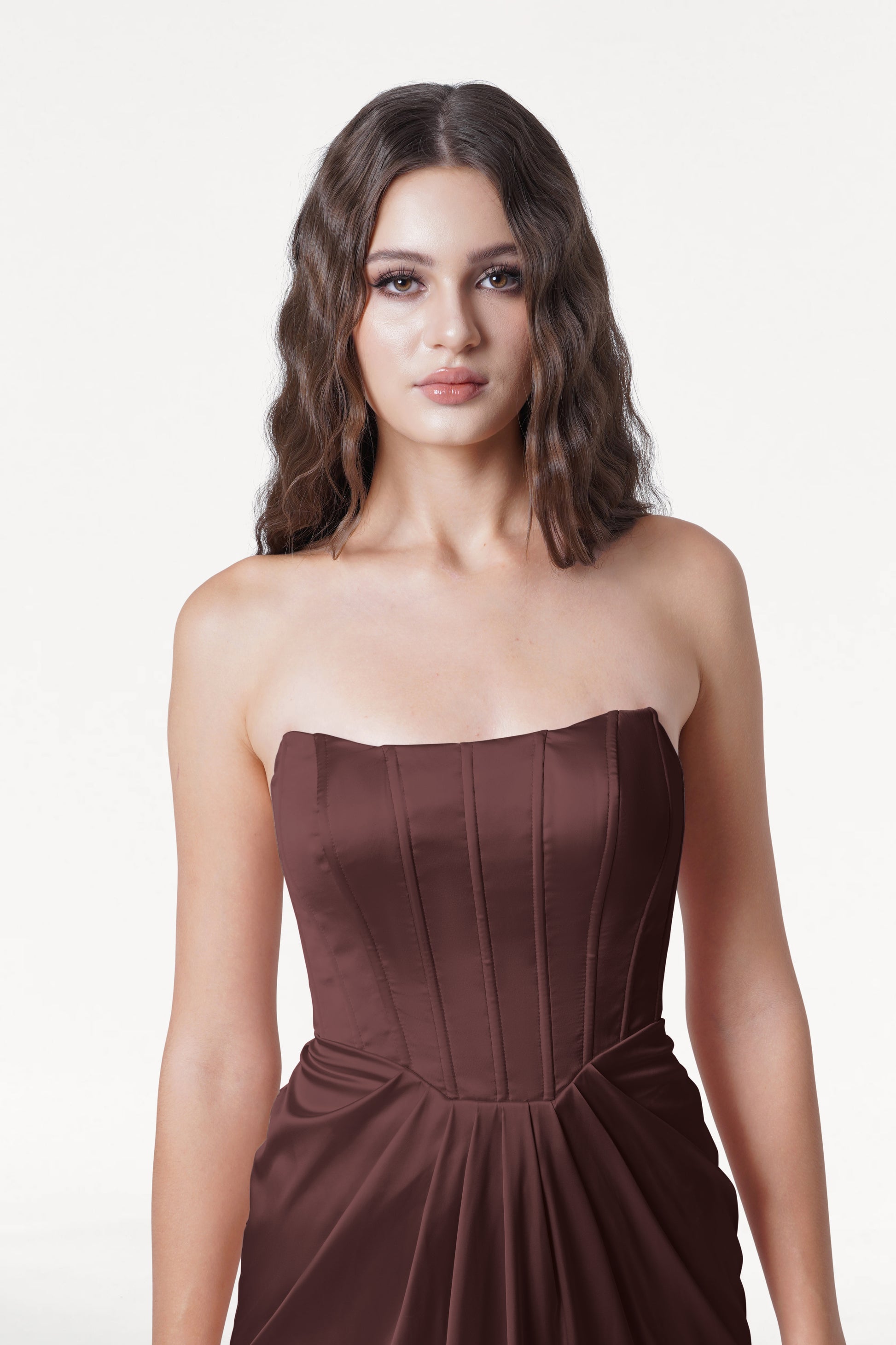 Woman wearing a strapless brown dress on a white background