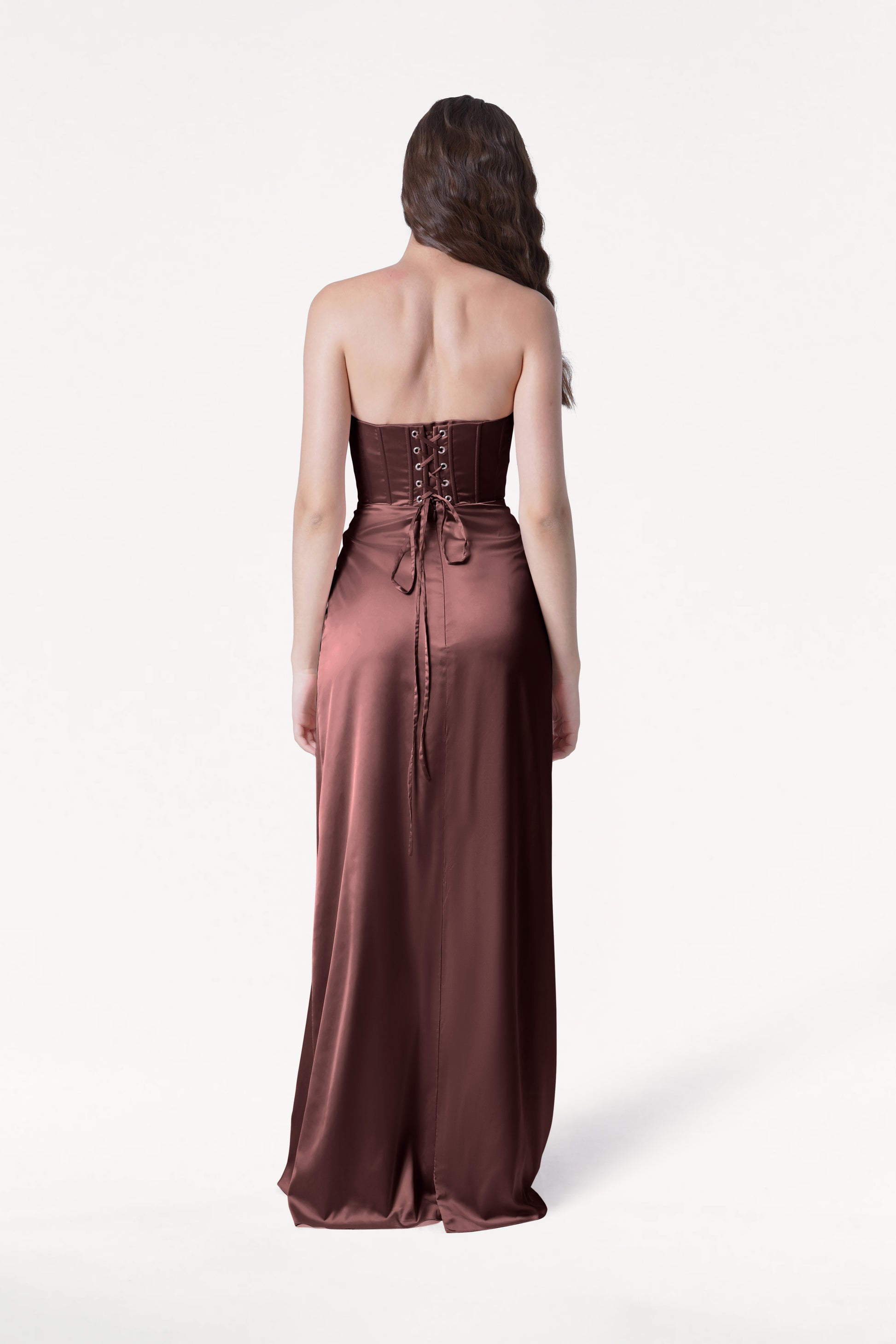 Woman wearing a strapless brown evening gown on a white background