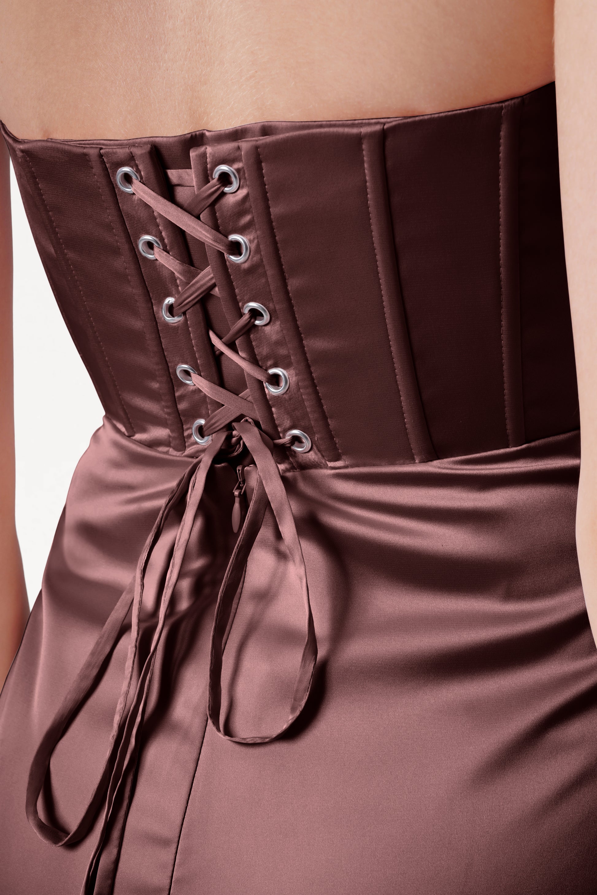 Close-up of a brown satin dress with lace-up front detail.
