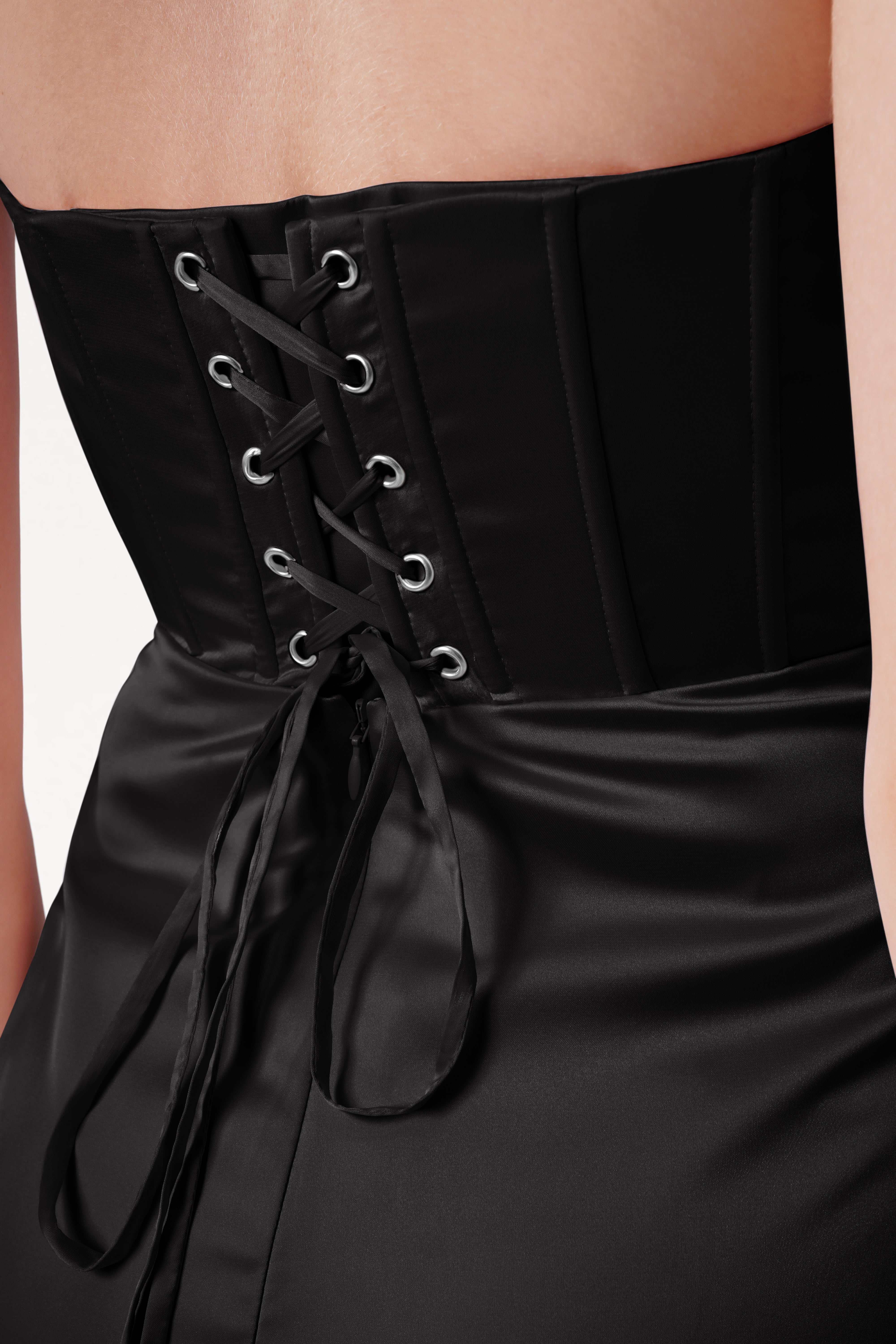 Black corset dress with lace-up back on a neutral background