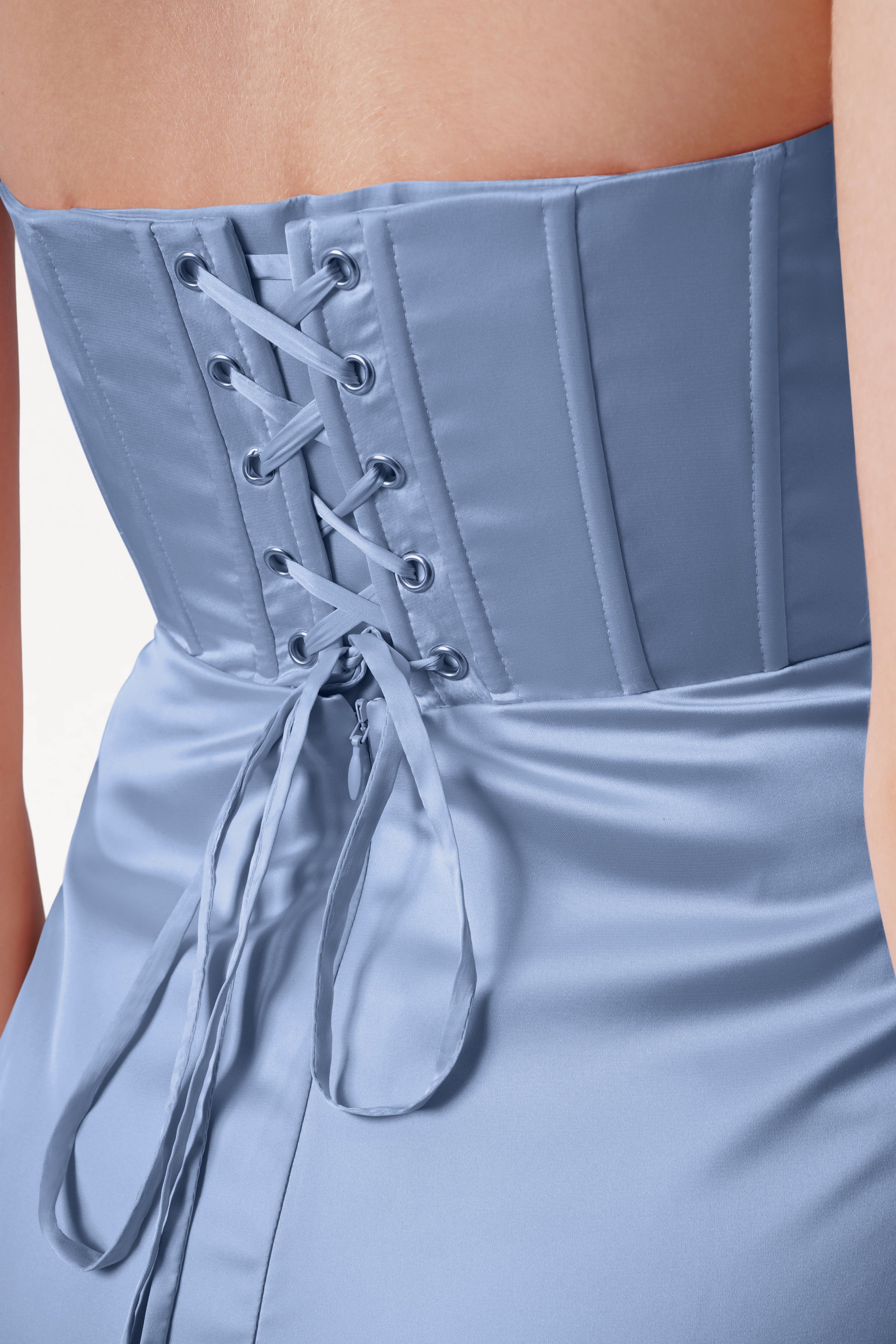 A close-up of the Selena Bridesmaid Dress in Dusty Blue Satin by TH&TH showcases its size-inclusive fit, corset-style lace-up back with metal eyelets, and the beautifully fitted bodice and upper back.