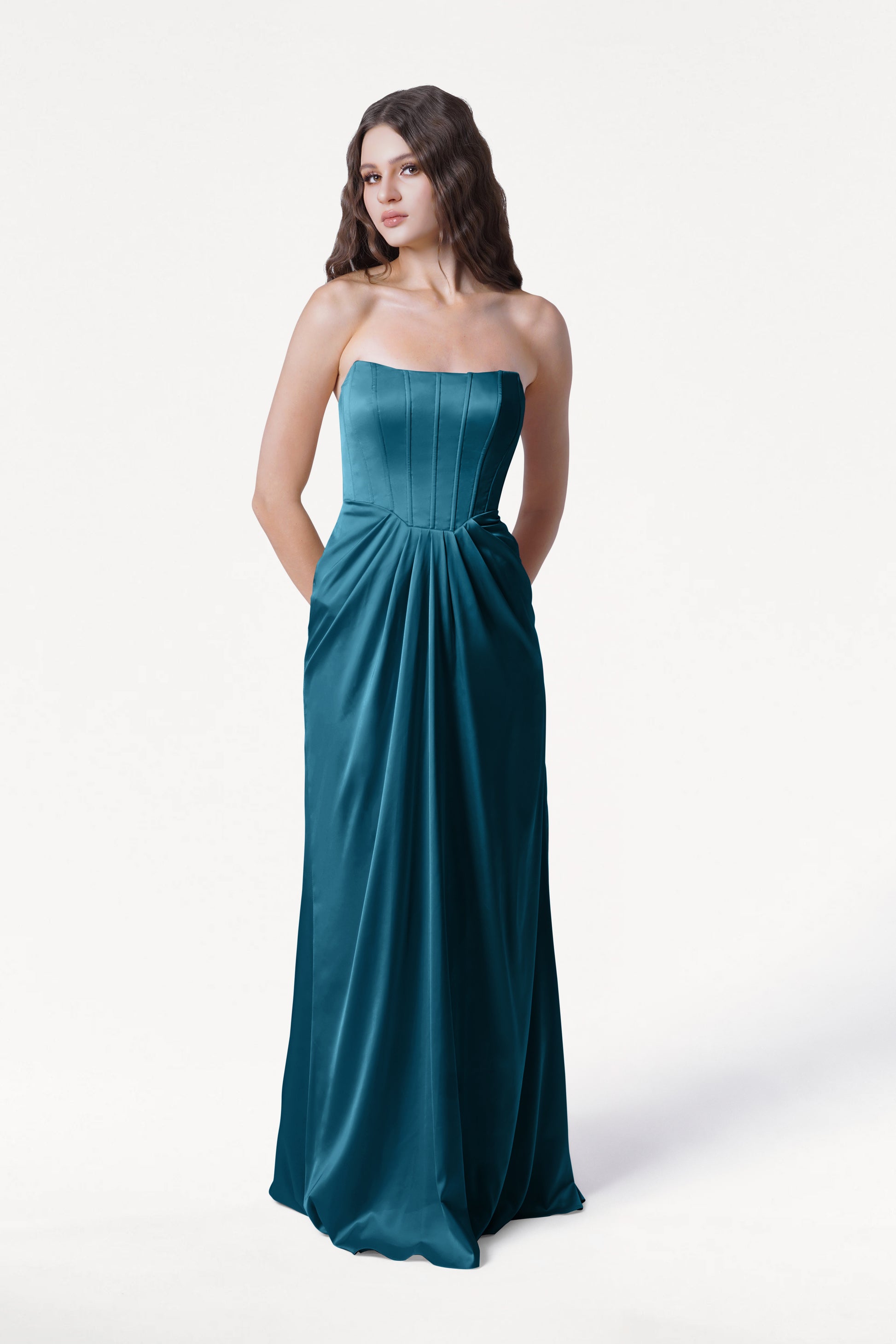 Woman wearing a strapless teal gown on a white background