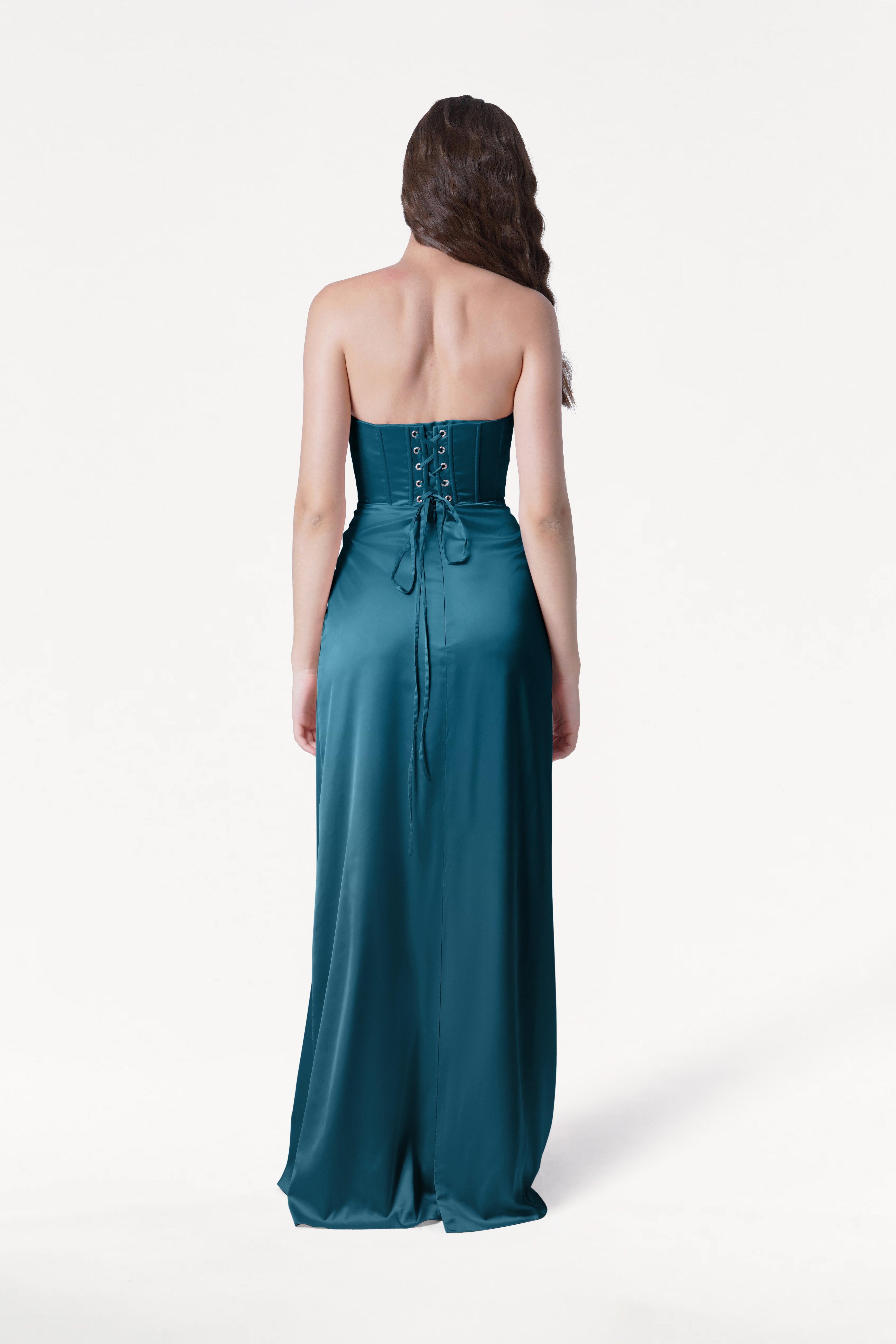Woman wearing a teal strapless gown on a white background