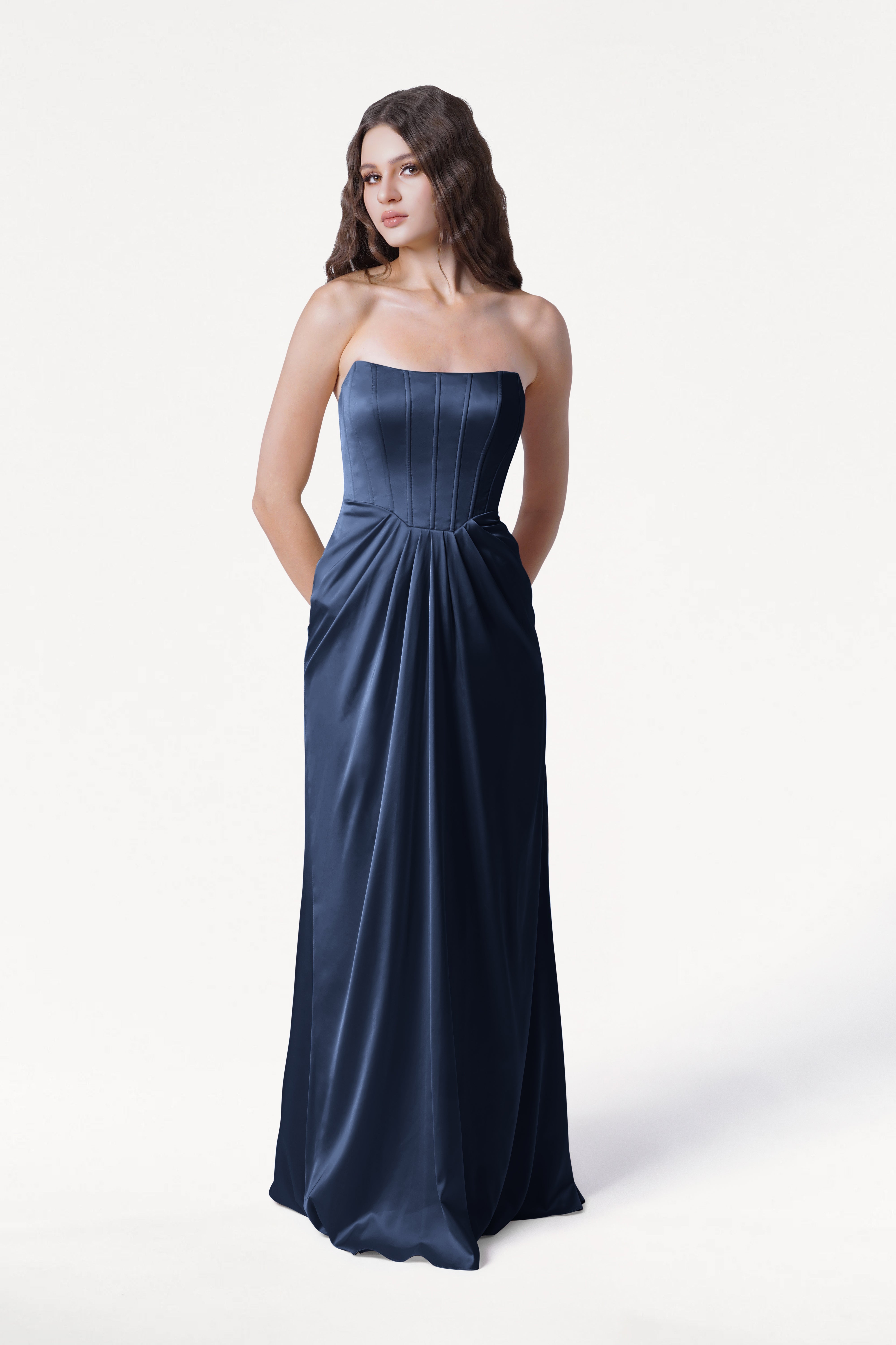 Woman wearing a strapless navy blue gown on a white background