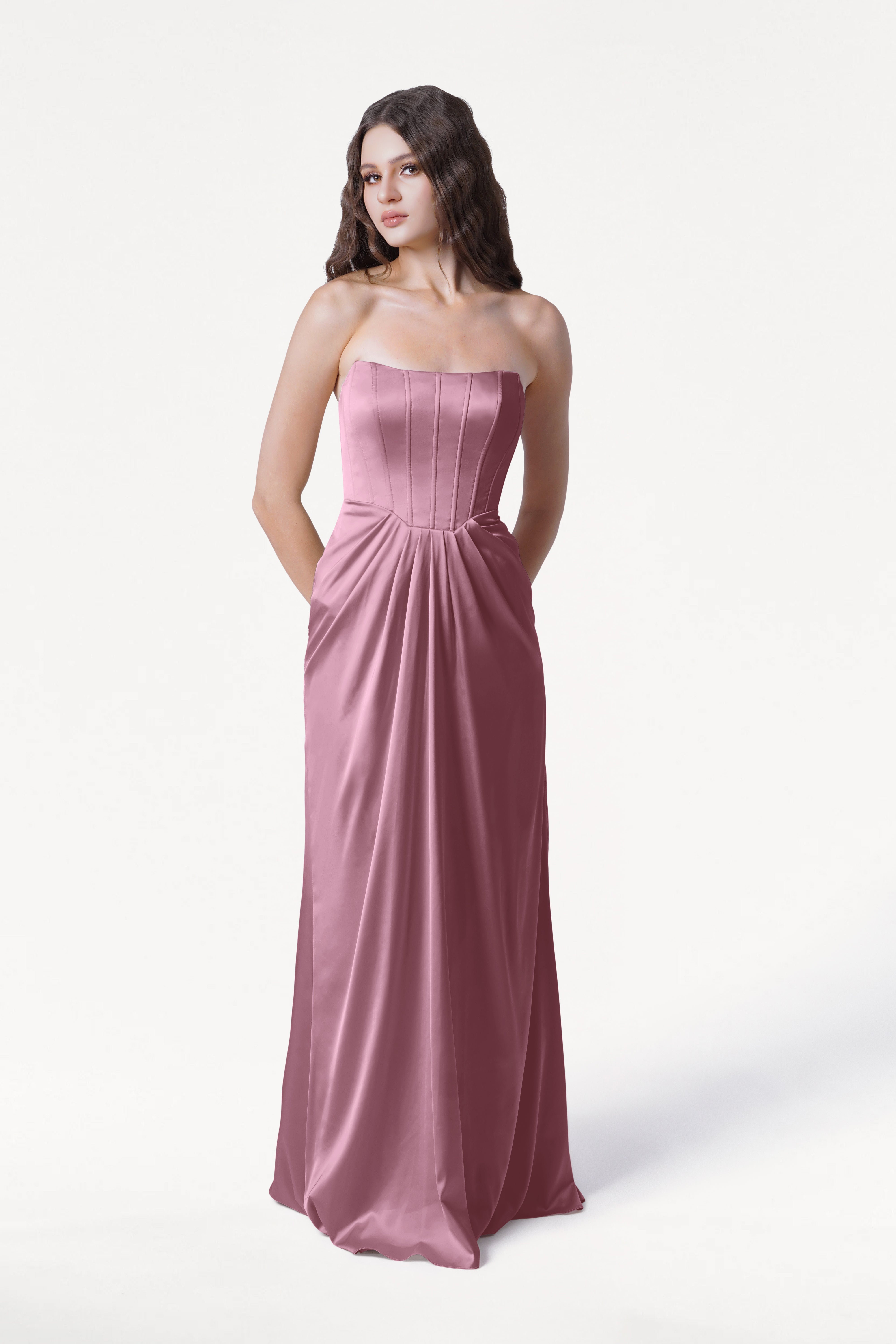 Woman wearing a strapless pink gown on a white background