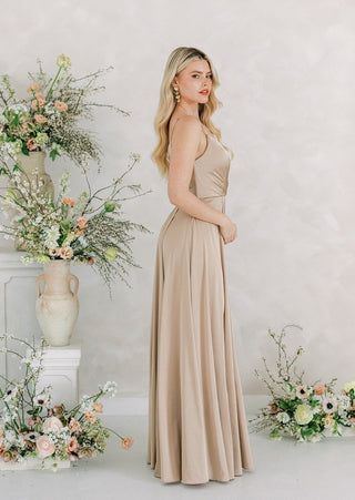 Champagne satin maxi bridesmaid dress with pleated bodice and full skirt.