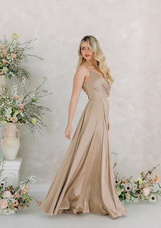 Champagne satin maxi bridesmaid dress with pleated bodice and full skirt.