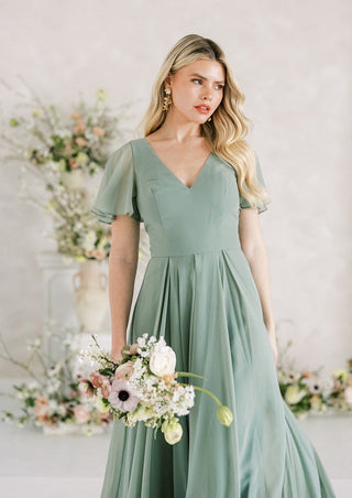 Sage green chiffon maxi bridesmaids dress with flutter sleeves and full skirt.