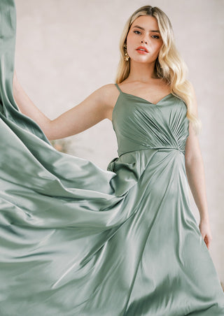 Sage green satin maxi bridesmaid dress with spaghetti straps and pleated bodice.