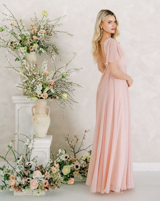 Blush pink chiffon maxi bridesmaid dress with flutter sleeves.