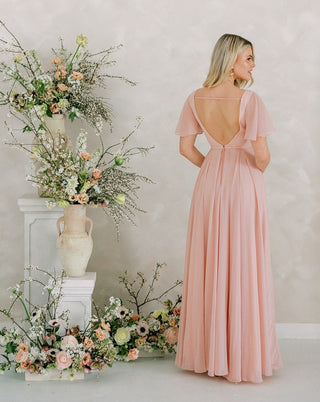 Blush pink chiffon maxi bridesmaid dress with flutter sleeves.