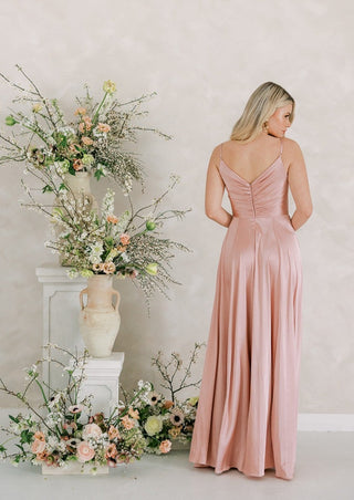 Blush satin bridesmaids maxi dress with pleated bodice and spaghetti straps and full skirt.
