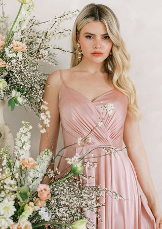 Blush satin bridesmaids maxi dress with pleated bodice and spaghetti straps and full skirt.