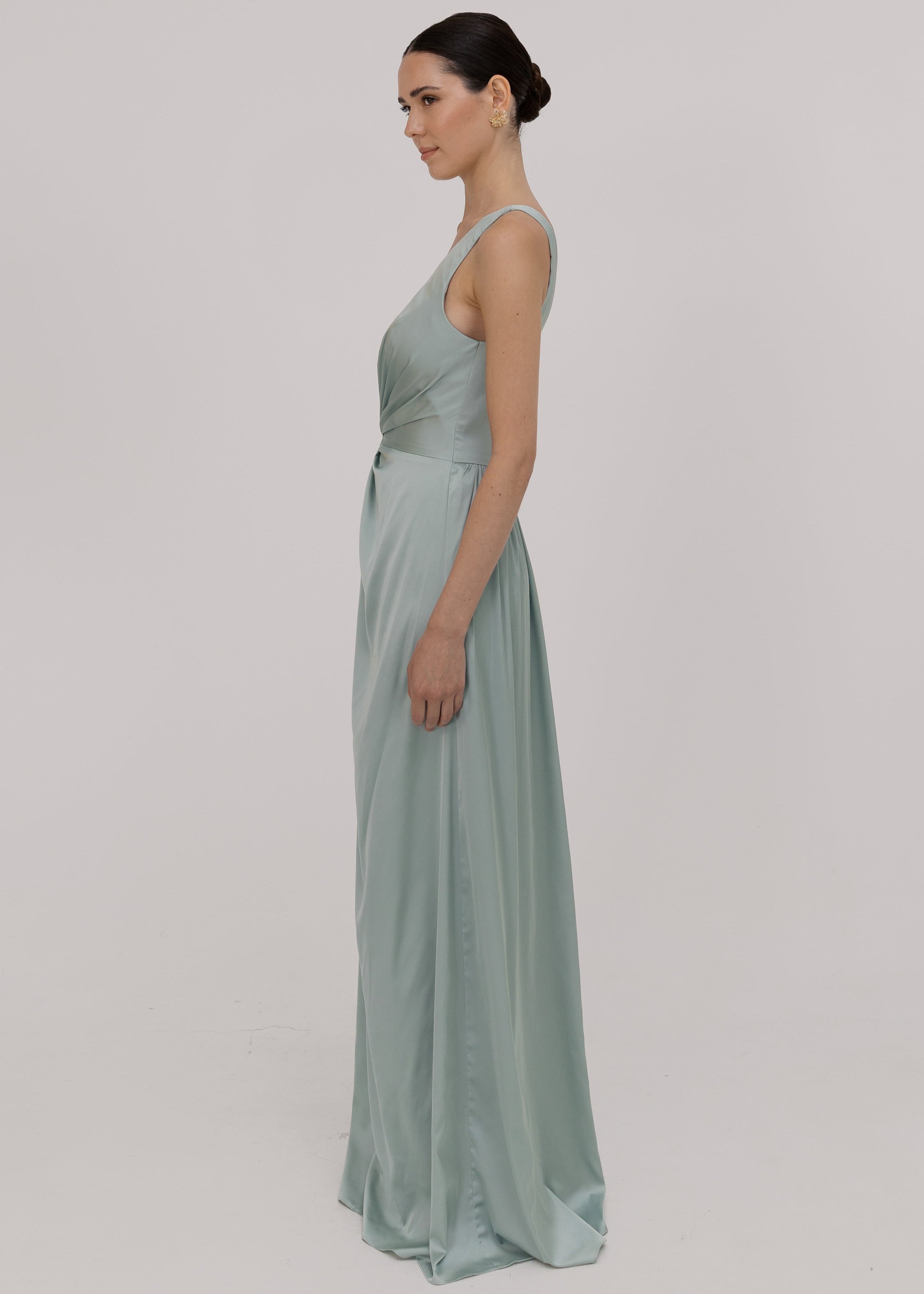 Woman wearing a green bridesmaid dress with one shoulder detail side view by TH&TH. 